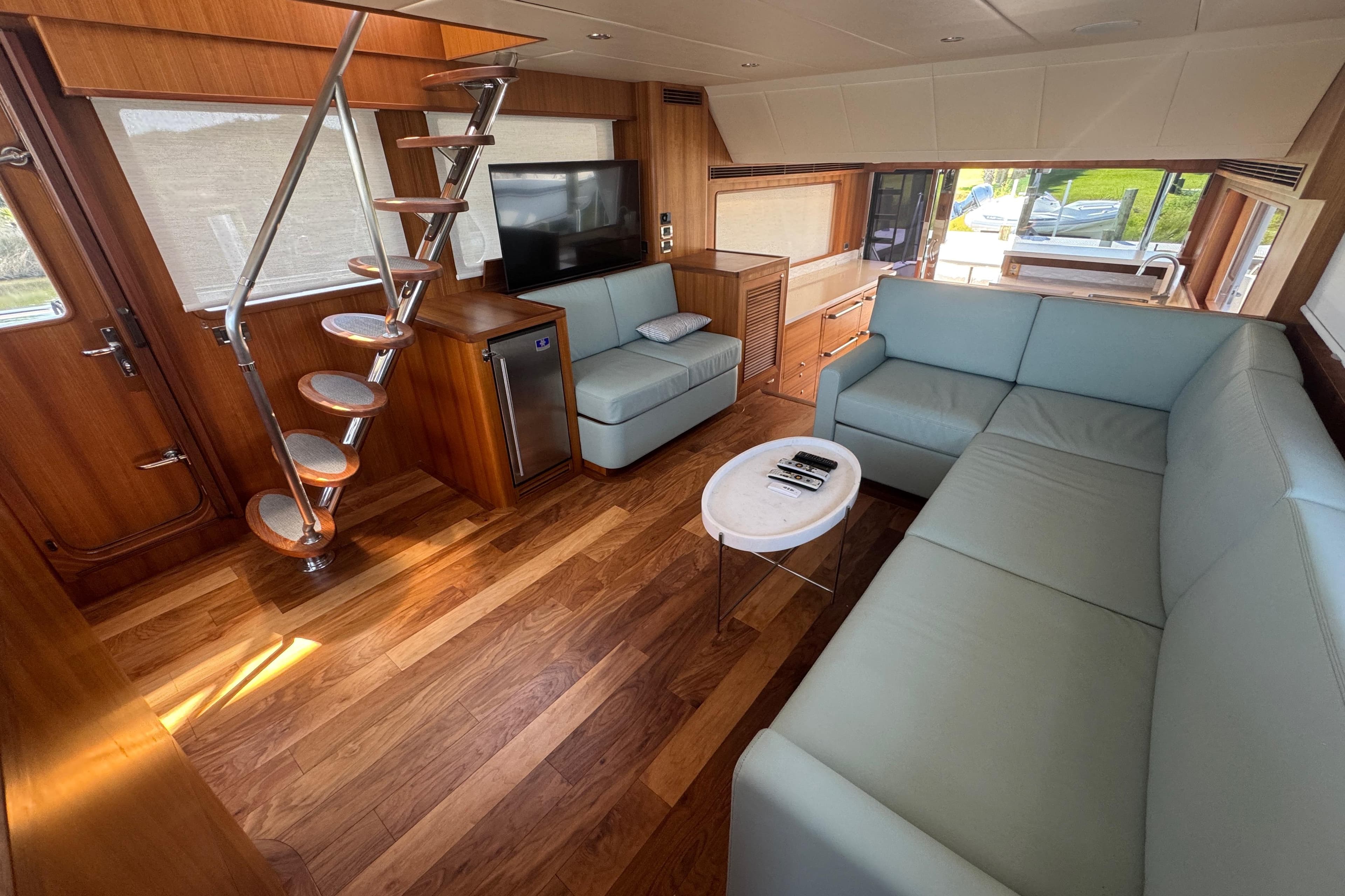 Luxurious interior of 2023 Outer Reef Yachts 670 Azure Motoryacht with modern seating and wooden flooring.