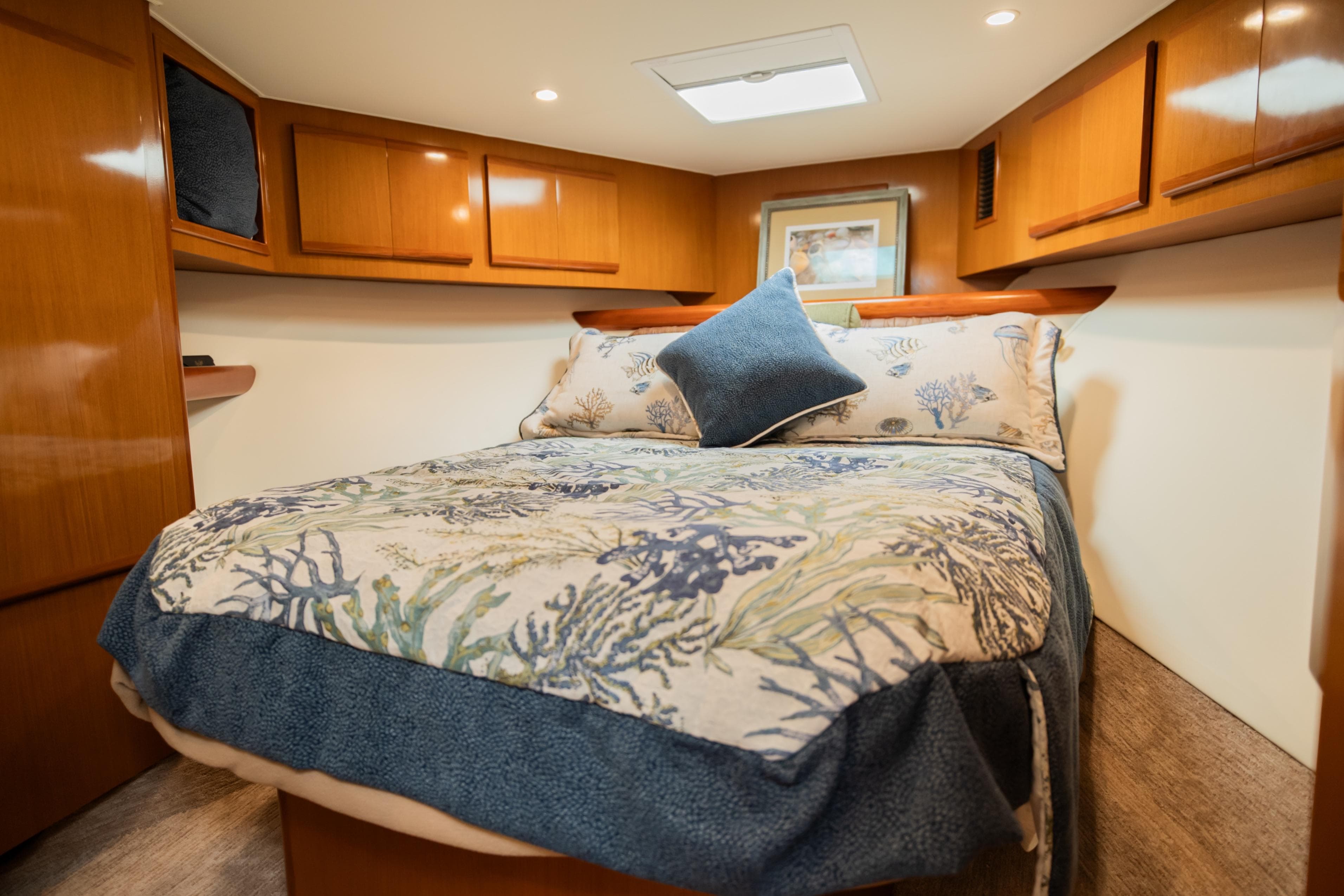 Luxurious cabin interior of 2008 Post 42 yacht with cozy bedding and wooden accents.