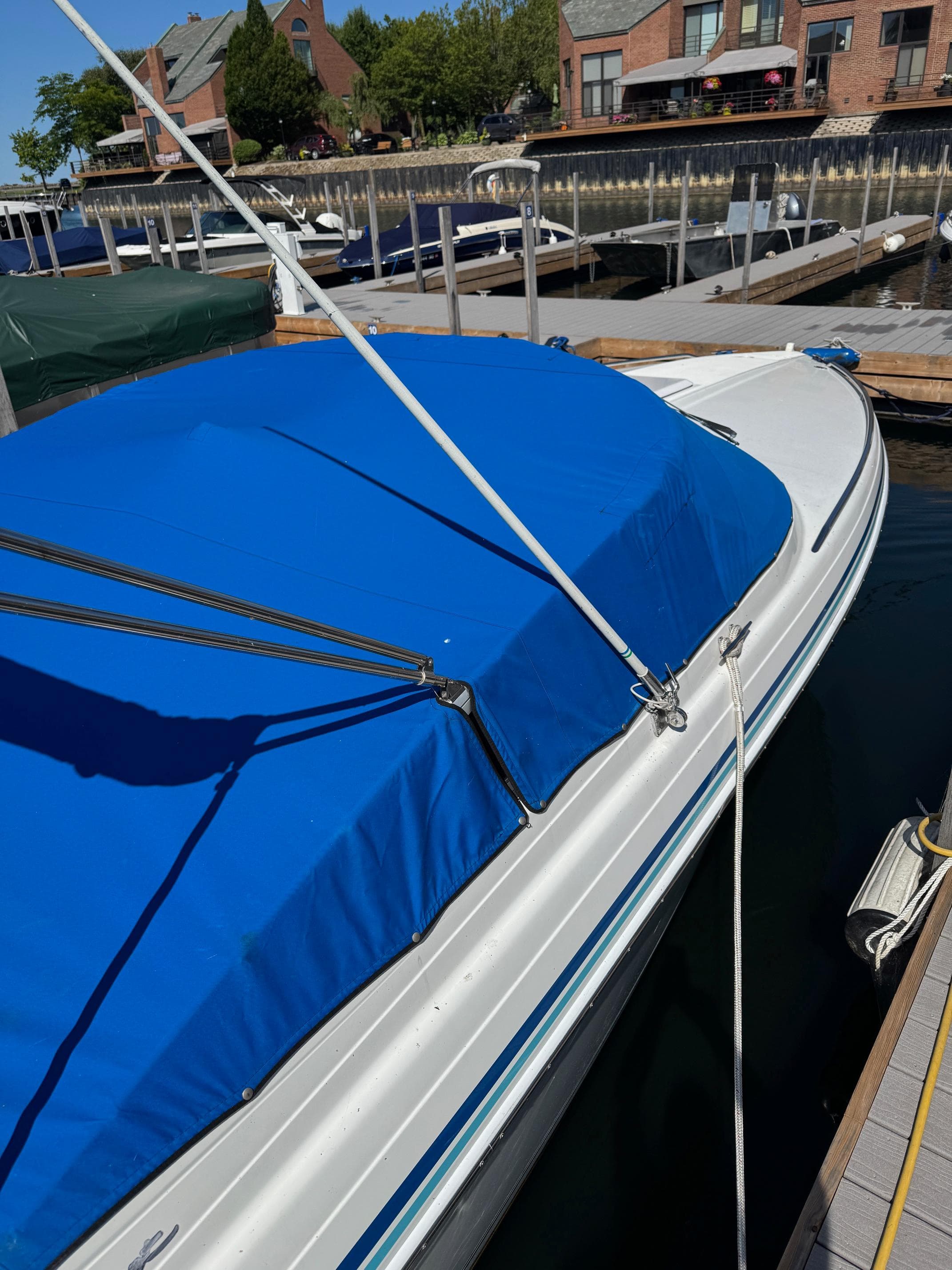 1996 Formula 280 SS boat with blue cover docked at marina.