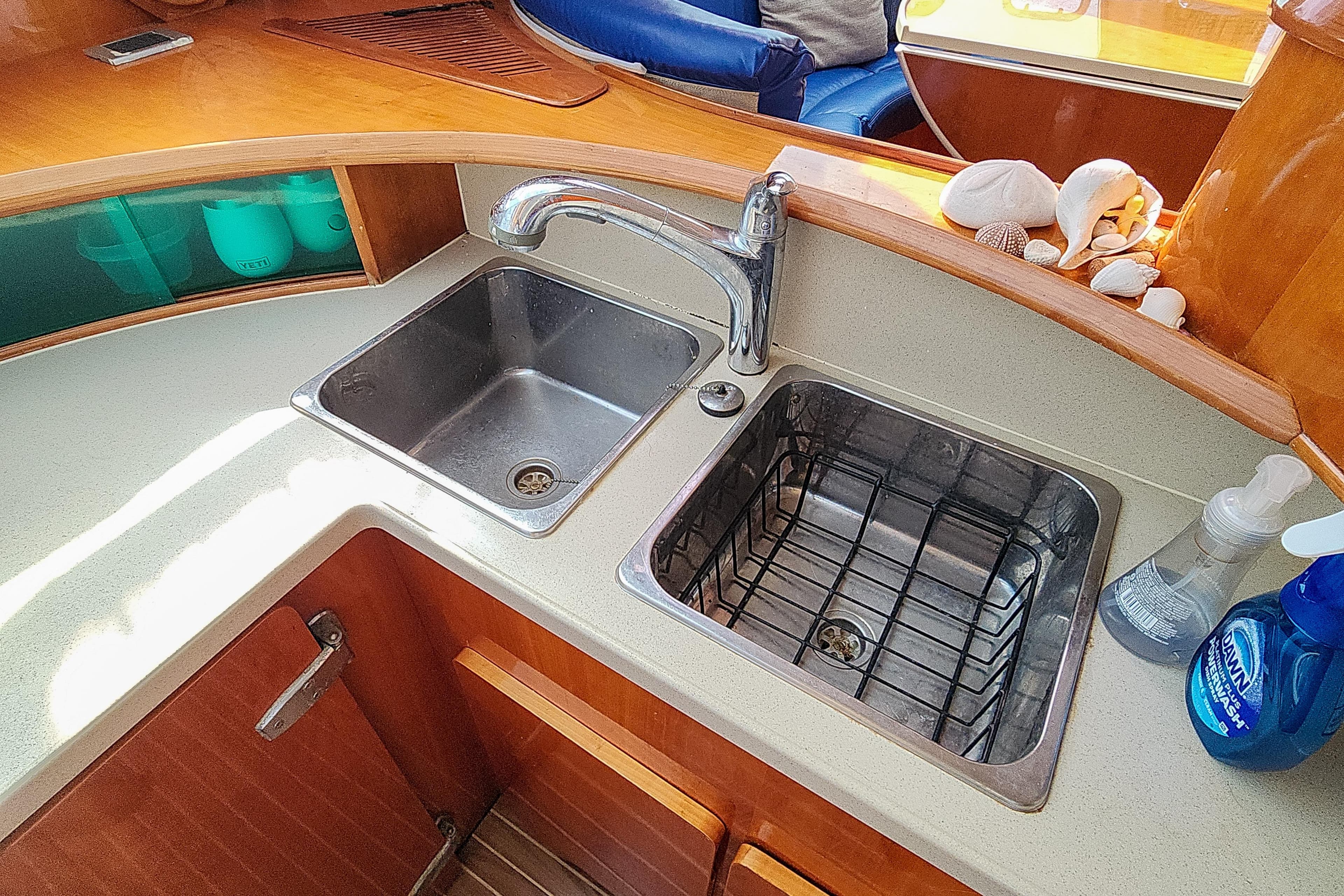 Kitchen sink area on a 2001 Privilege 435 yacht, featuring dual basins and decorative seashells.
