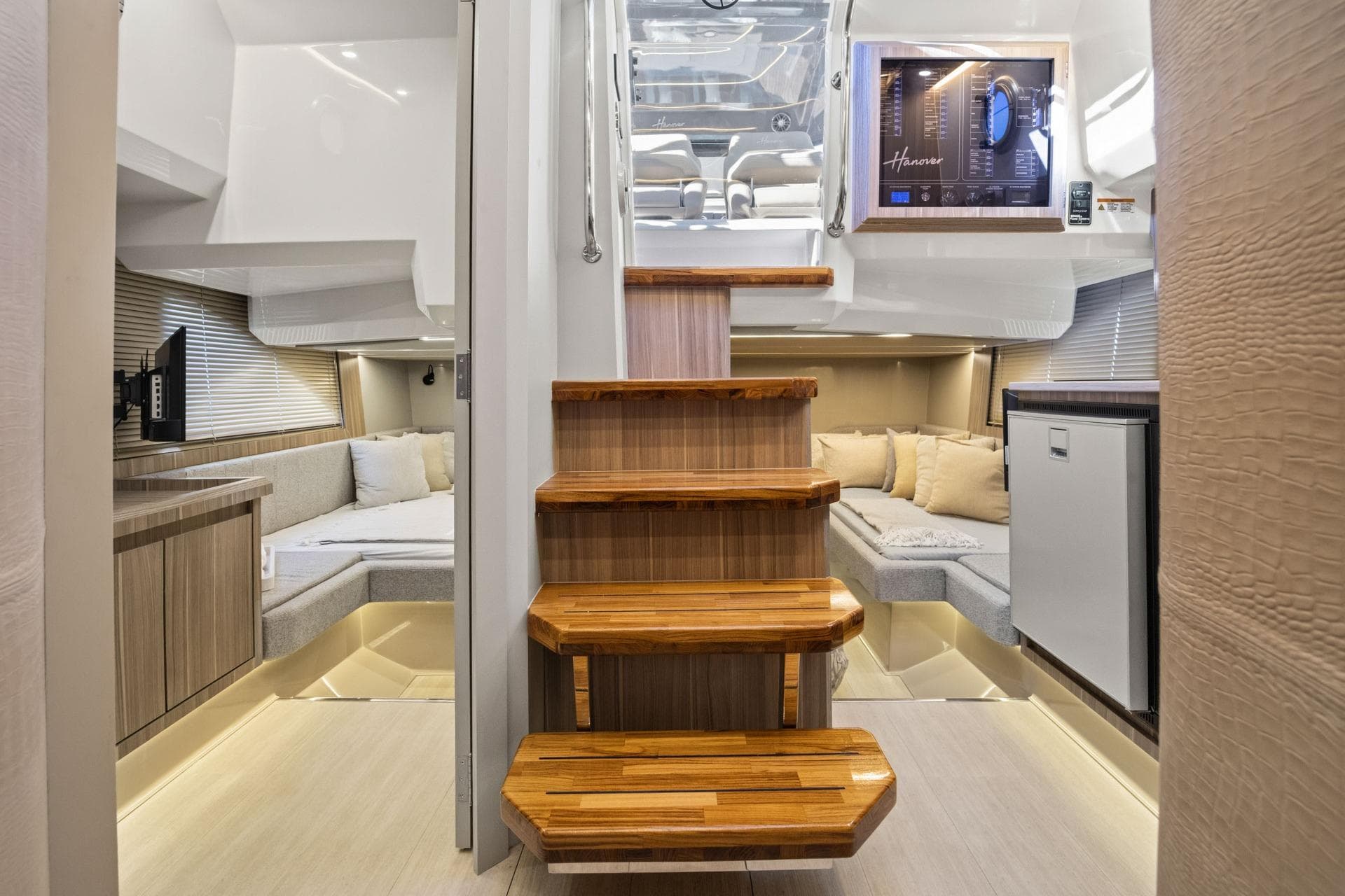 Luxurious interior of 2026 Hanover 447 yacht with wooden stairs and cozy seating area.
