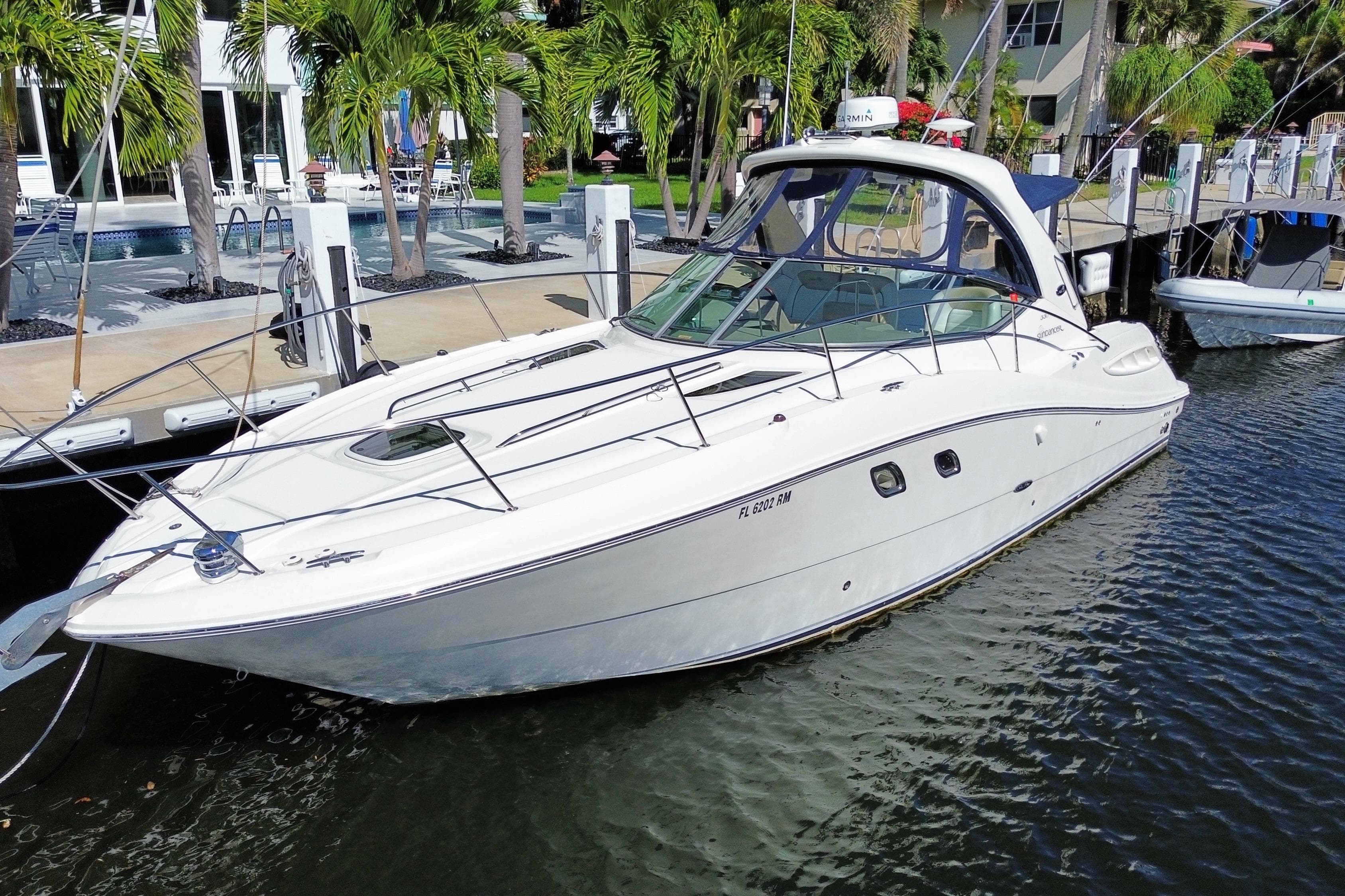 2008 Sea Ray Sundancer 330 docked near palm trees and waterfront homes.