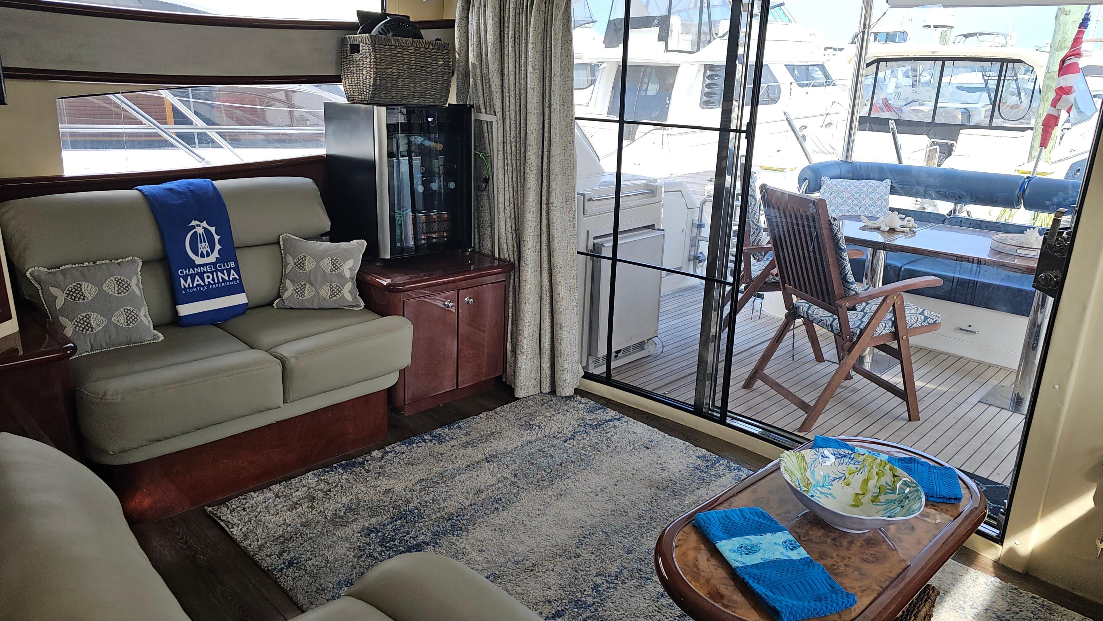 Luxurious 2005 Neptunus 56 Flybridge yacht interior with cozy seating and marina view.