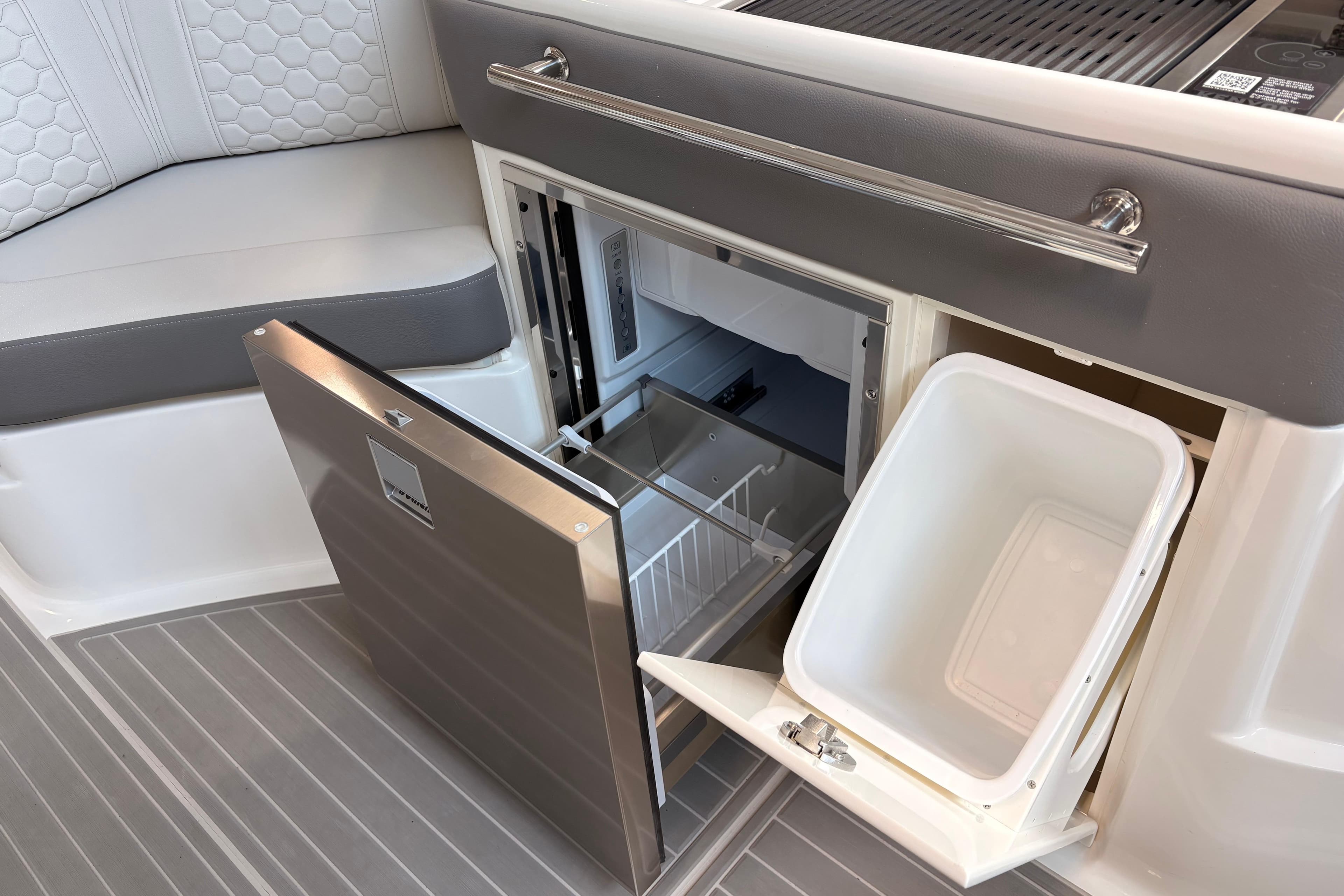 2026 Sea Ray Sundancer 320 interior with open fridge and storage compartment.