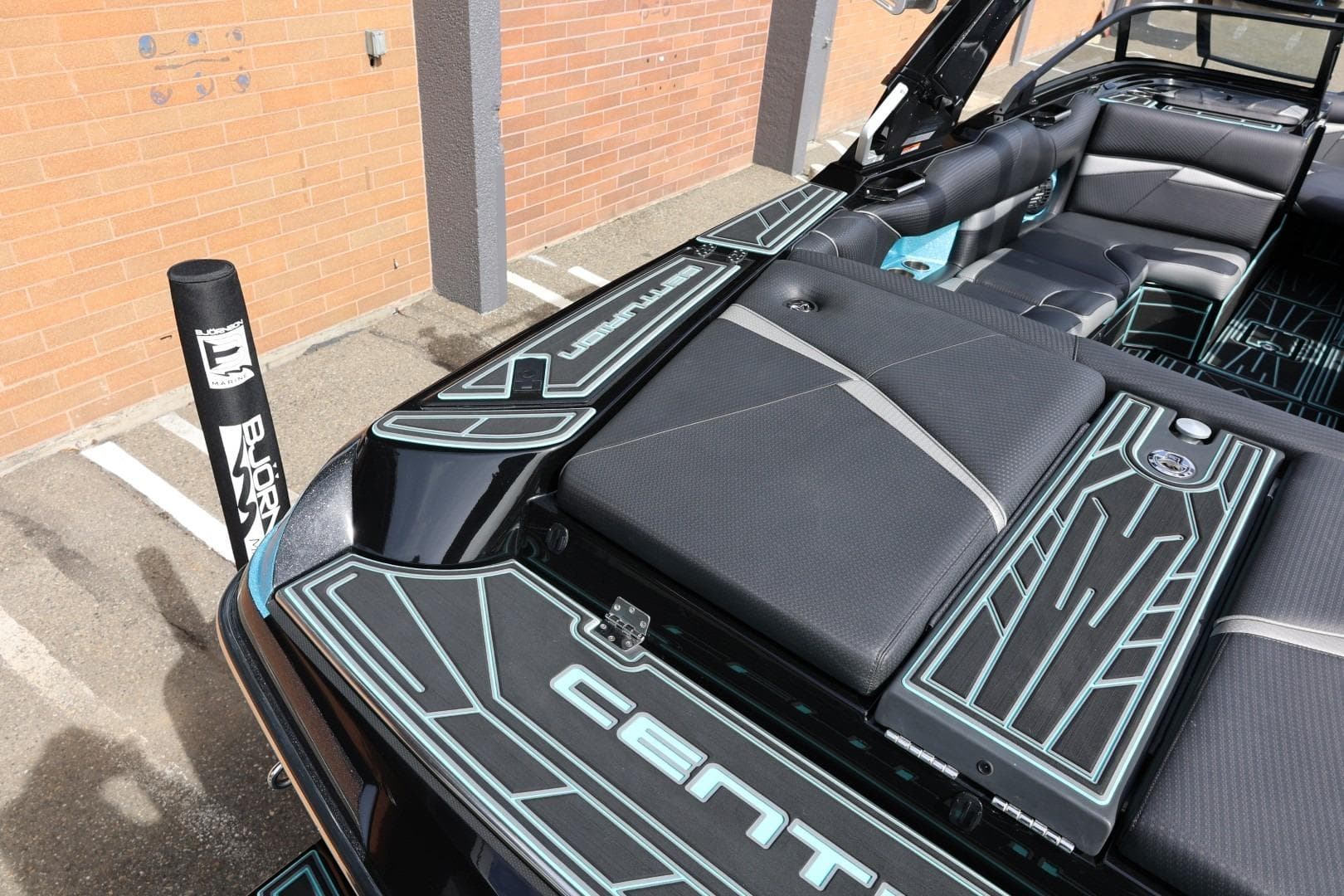 2021 Centurion Fi23 boat interior with sleek black and teal design, parked outdoors.