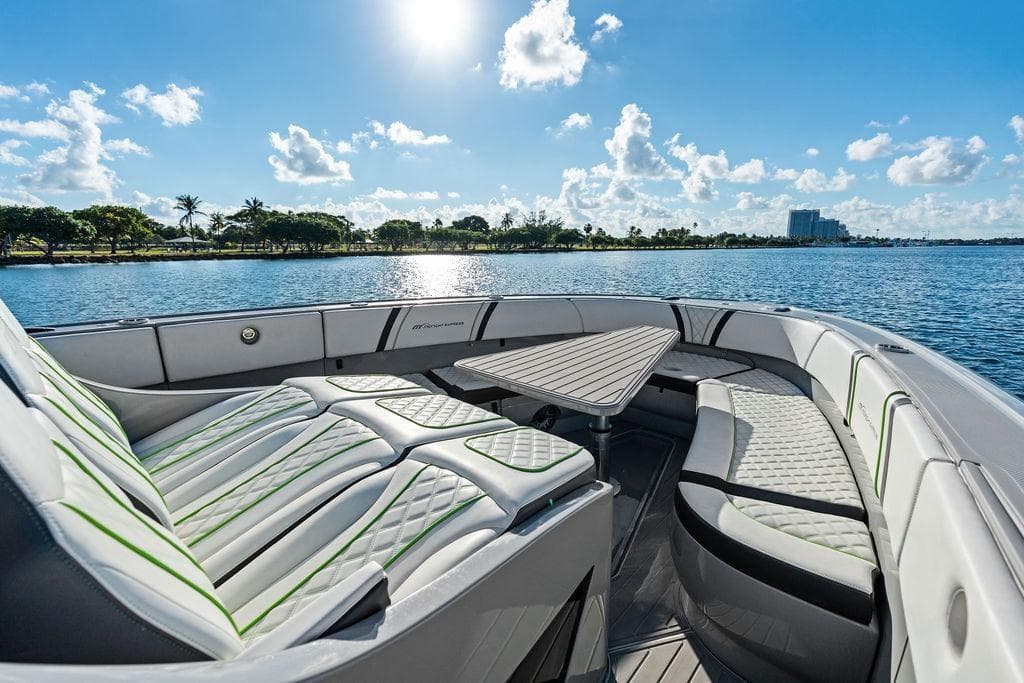 Luxurious 2022 Midnight Express 43' Solstice boat interior with seating and table, on a sunny day.