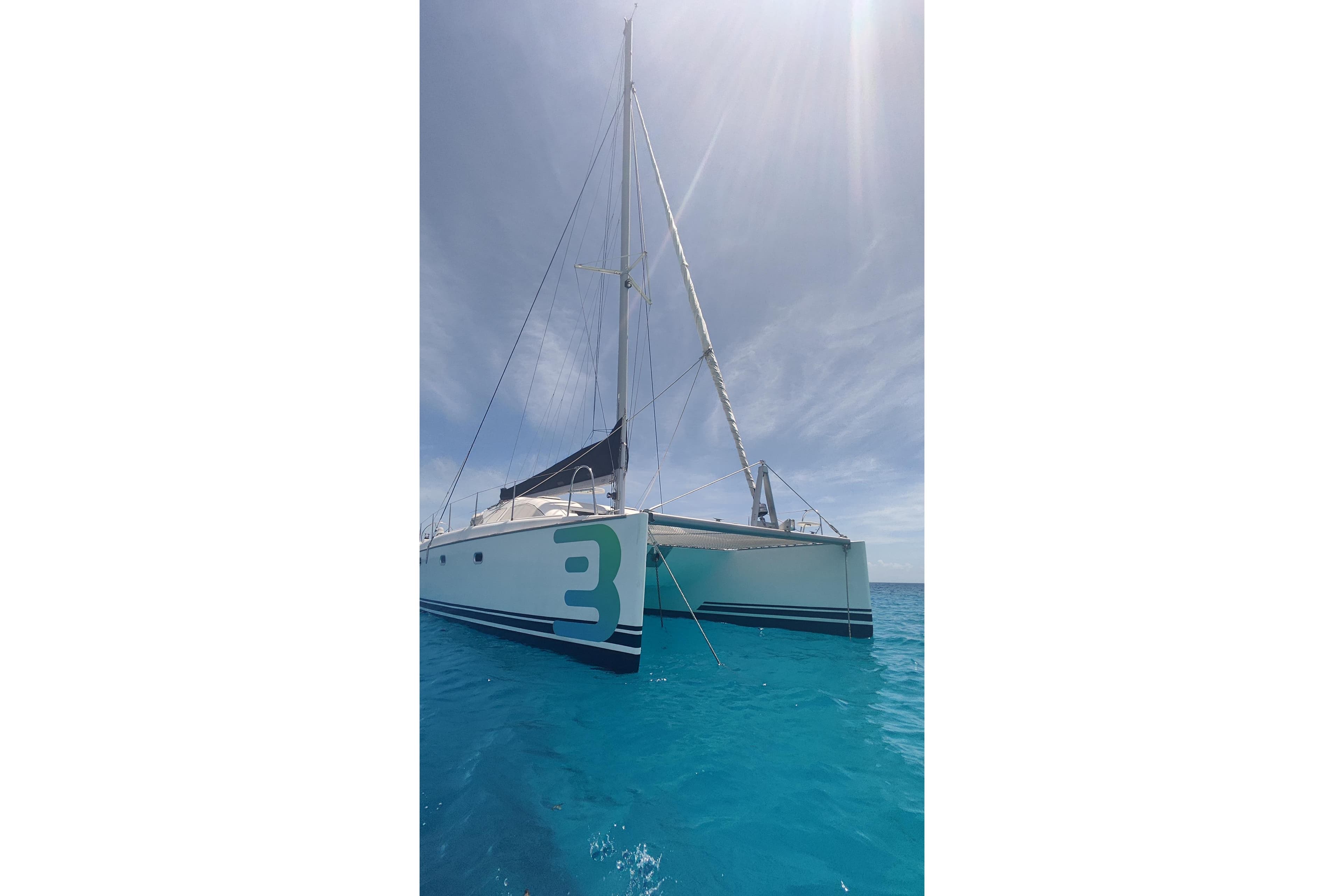 Sailing catamaran Dufour Nautitech 435, 1998 model, anchored in clear blue waters.