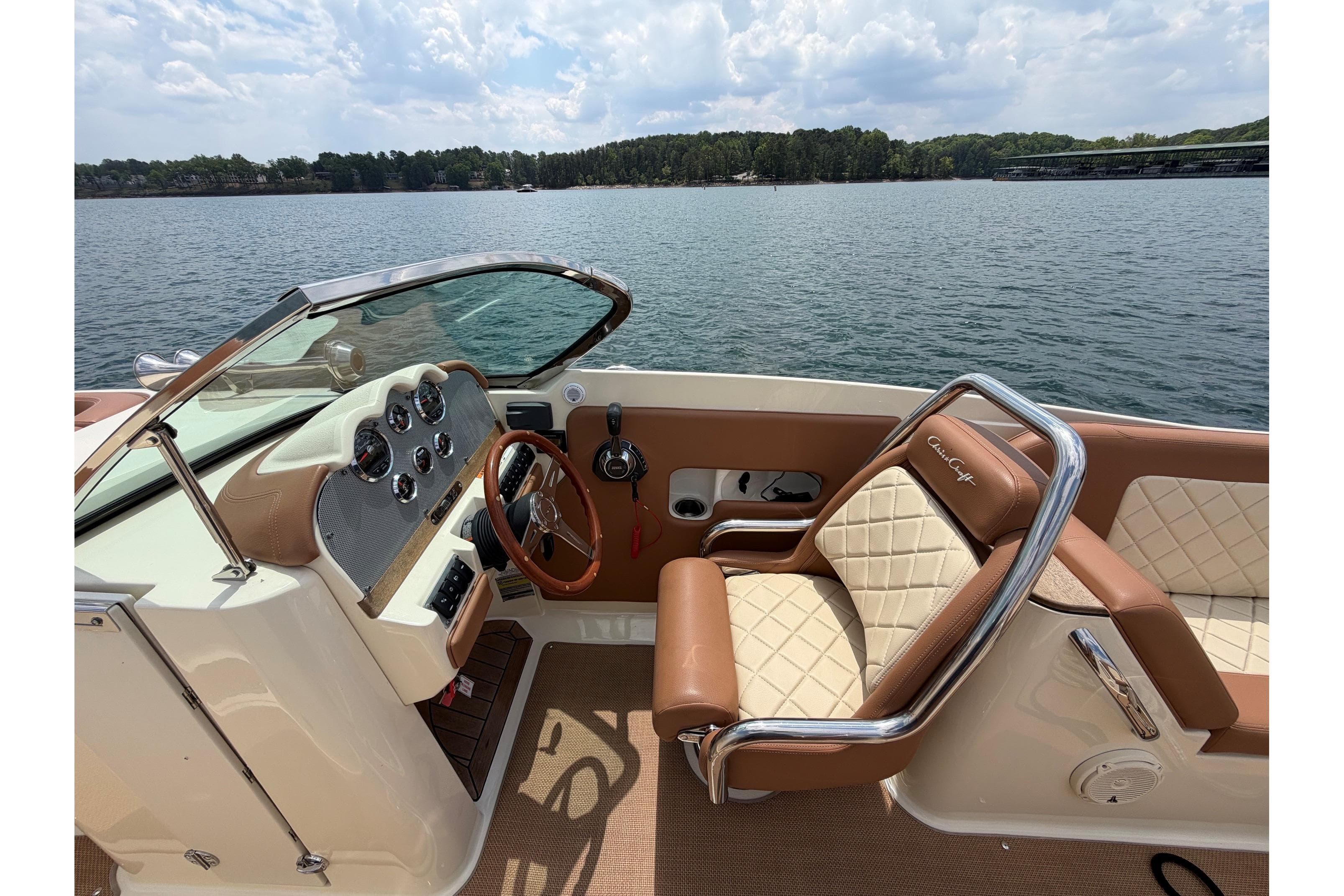 2017 Chris-Craft Launch 25 boat interior with luxurious seating and dashboard on a serene lake.