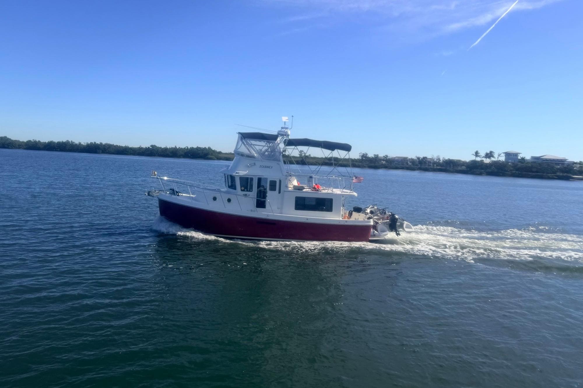 American Tug 365 Flybridge 2012 cruising on a sunny day in calm waters.