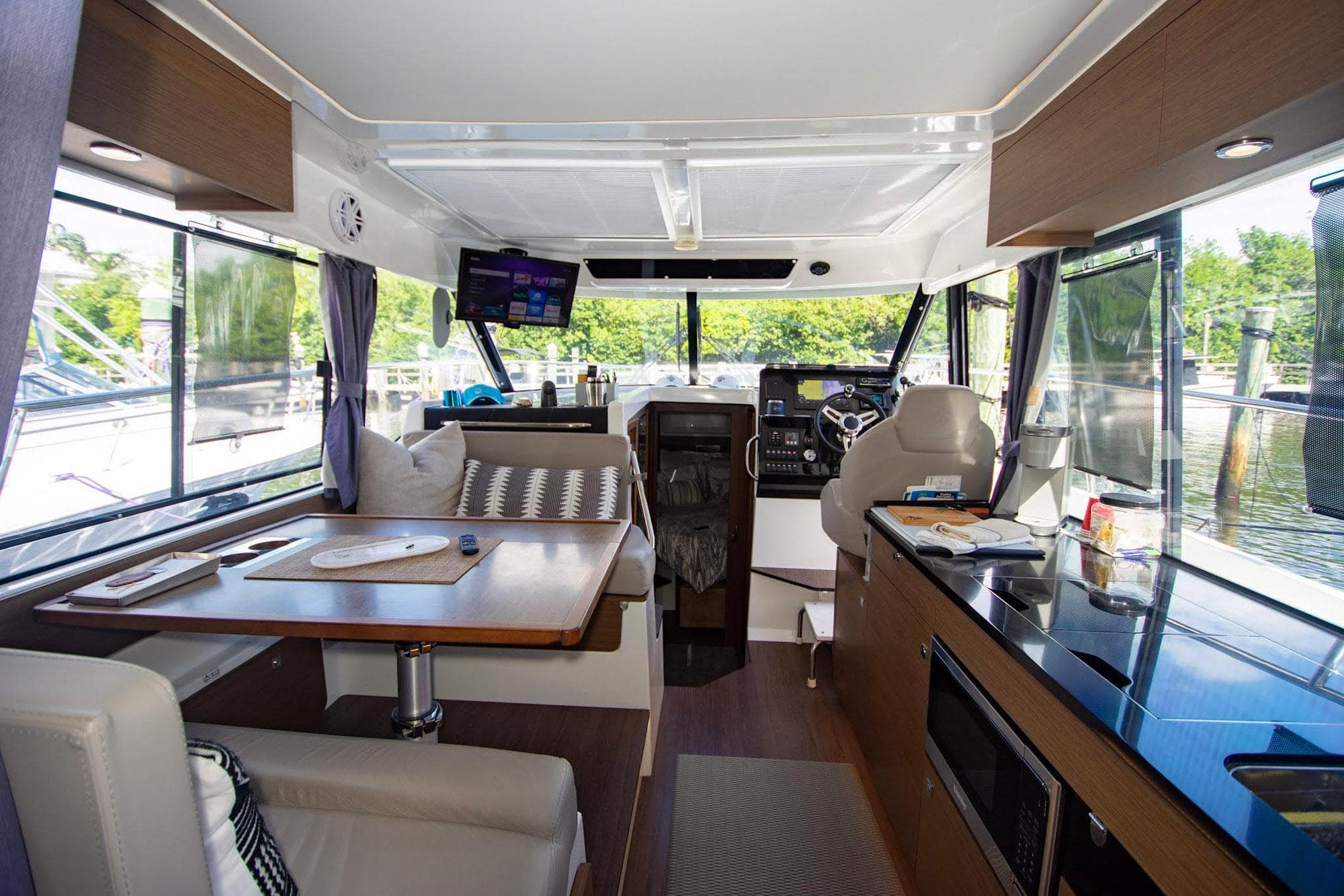Interior of 2021 Jeanneau NC 1095 boat, featuring modern kitchen and seating area.