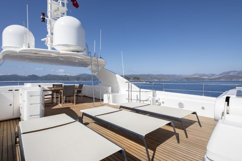 Luxurious CRN 129 yacht deck with sun loungers and dining area, 2009 model.