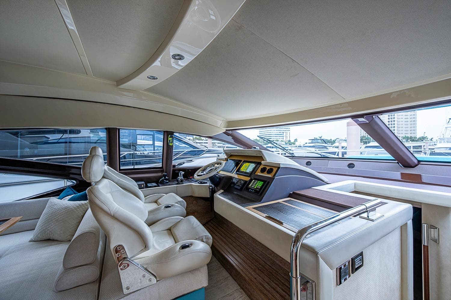 Luxurious interior of a 2011 Azimut 70 yacht with modern helm and plush seating.
