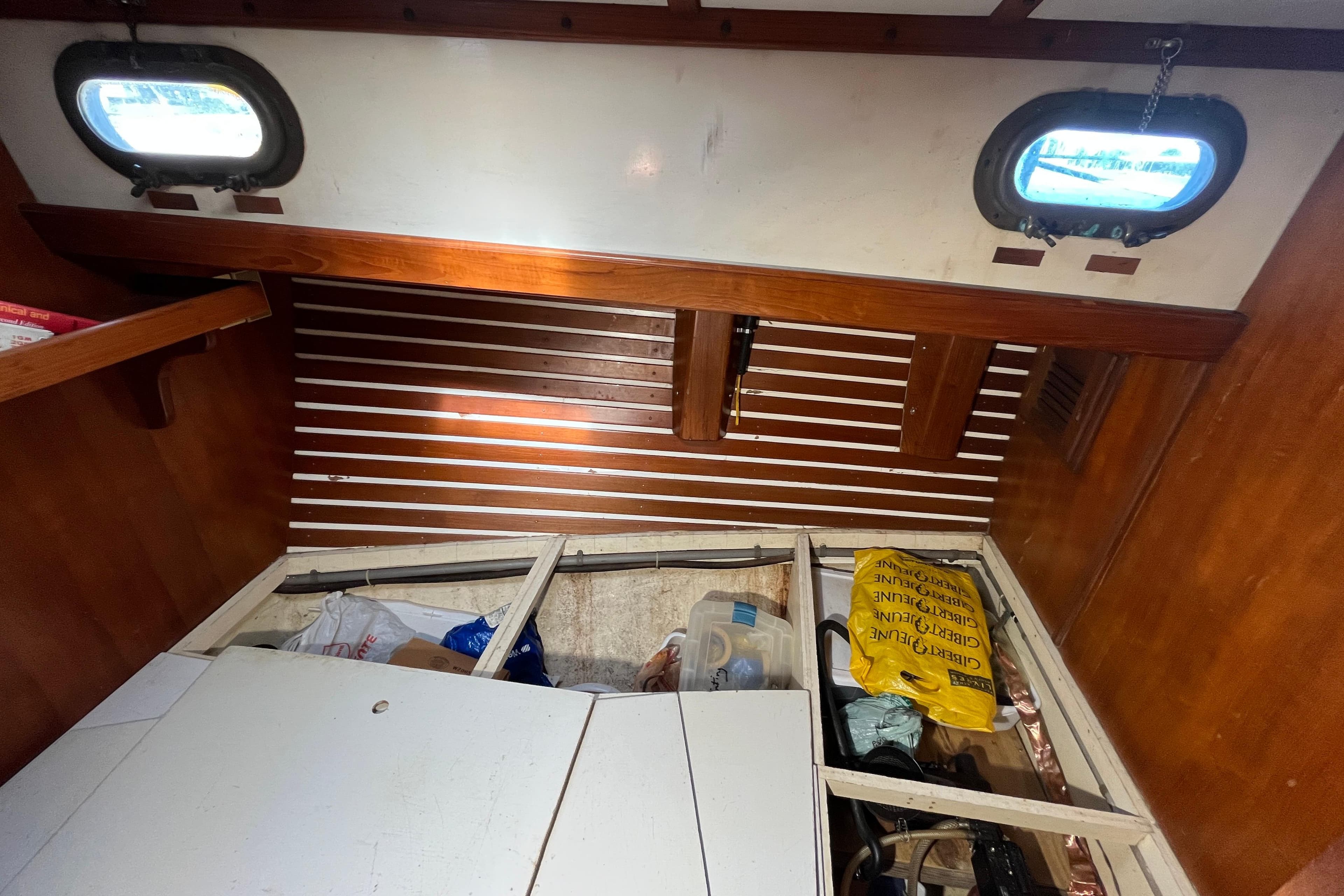 Interior of 1982 Tayana 37 sailboat with storage compartments and wooden paneling.
