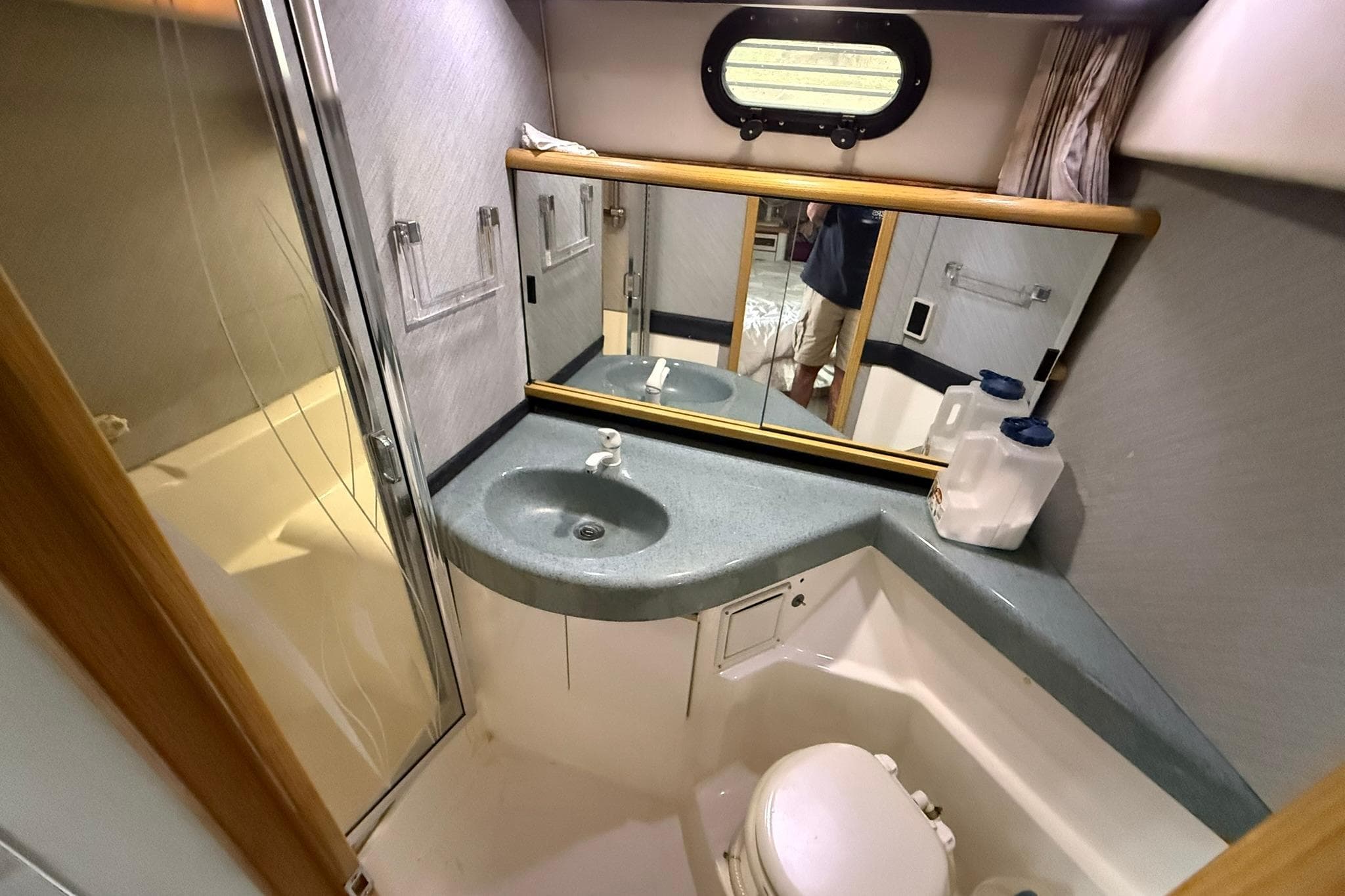 Primary head interior of 1991 Bayliner 4387 Motoryacht with sink, mirror, and toilet.