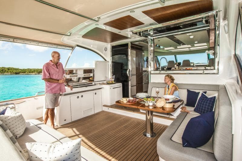 2024 Belize 66 Sedan yacht interior with people dining and relaxing.