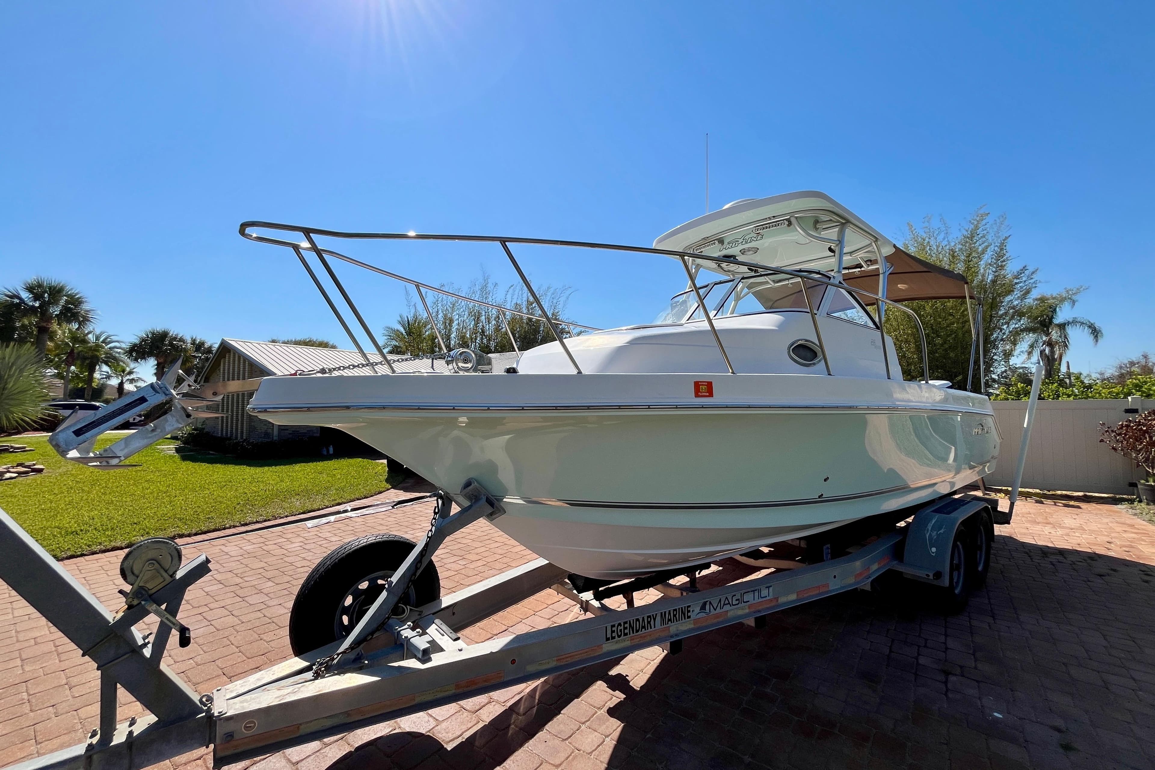 2018 Pro-Line 26 Express boat on trailer, parked on brick driveway under clear blue sky.