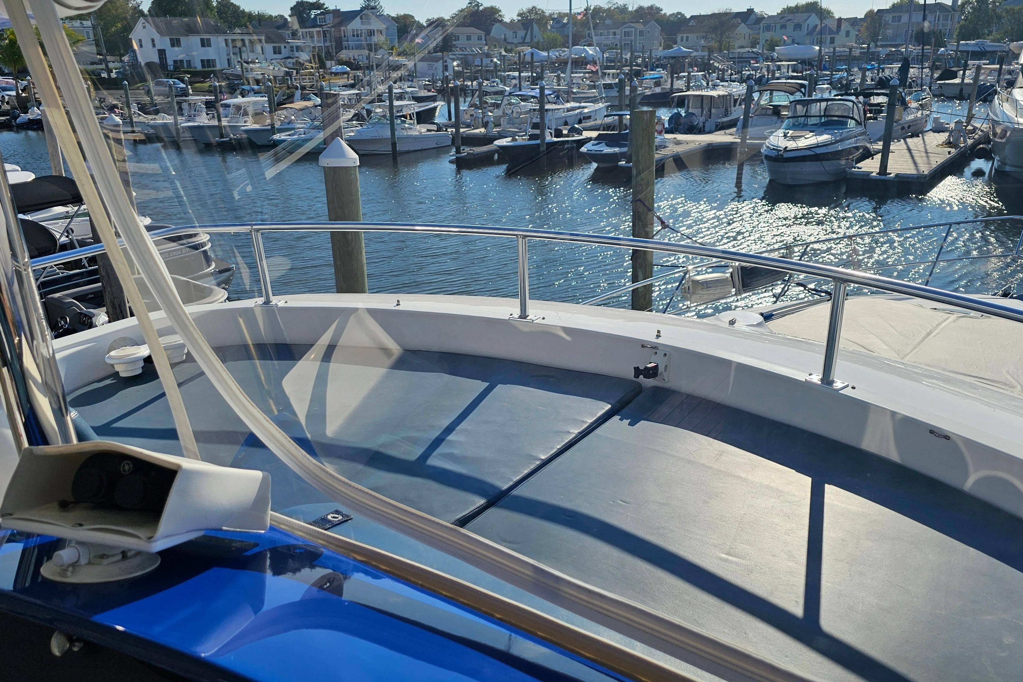 2005 Neptunus 56 Flybridge yacht docked at a marina with scenic waterfront views.