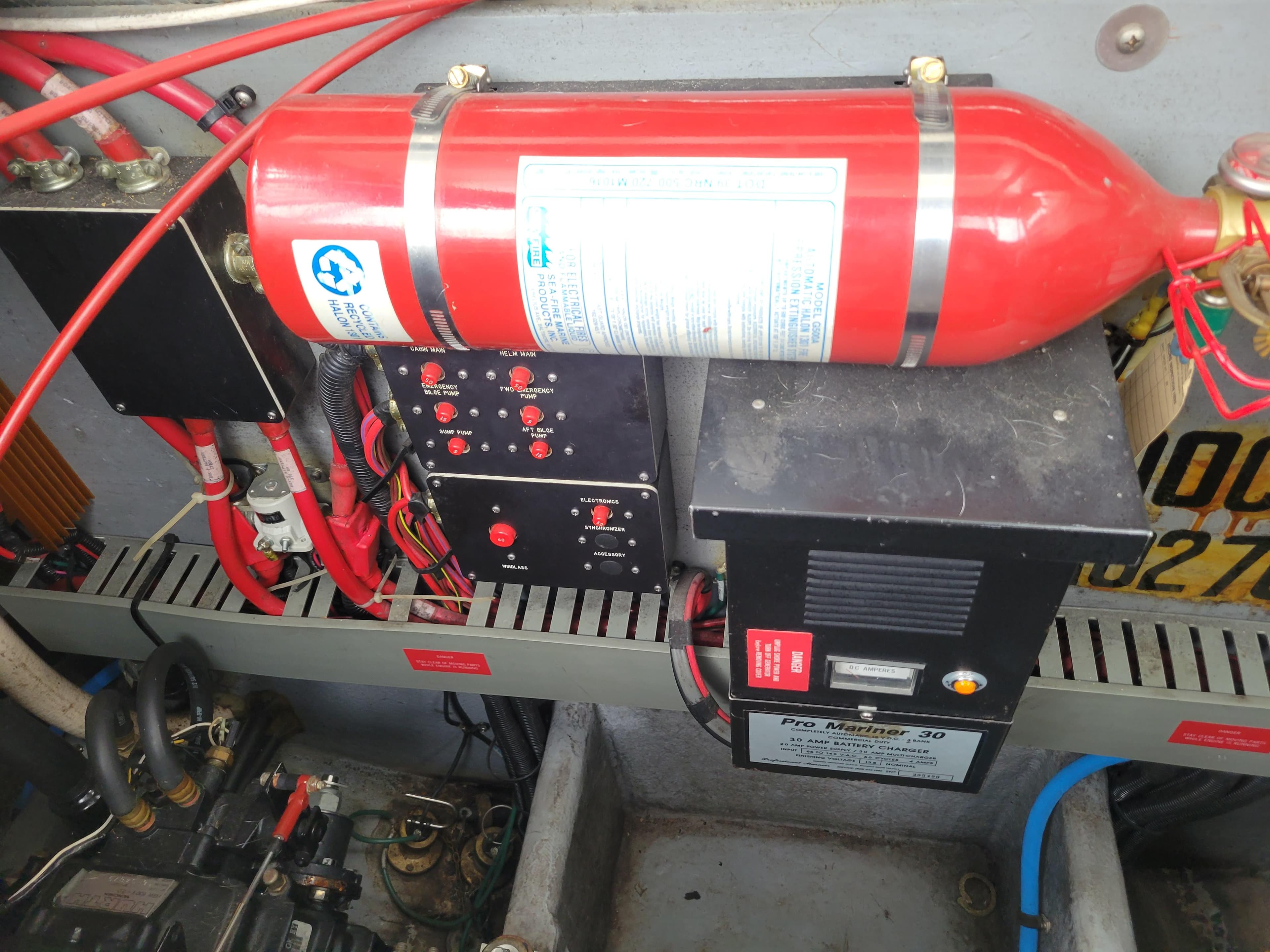 Engine compartment of 1995 Sea Ray 370 Sundancer with fire extinguisher and electrical components.