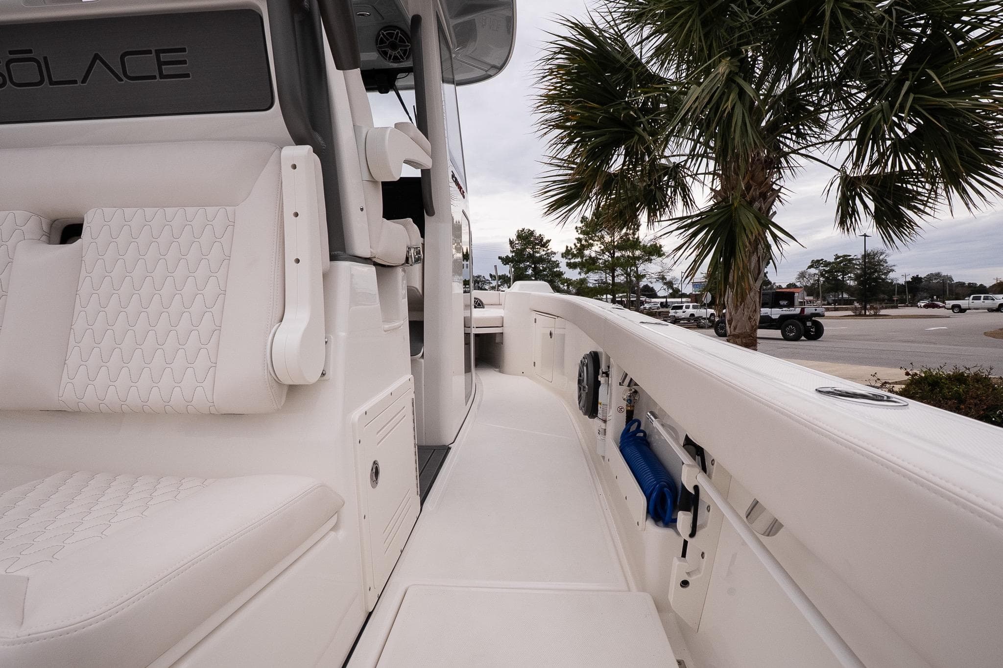 2026 Solace 28 HCS boat interior with white seating and palm tree background.