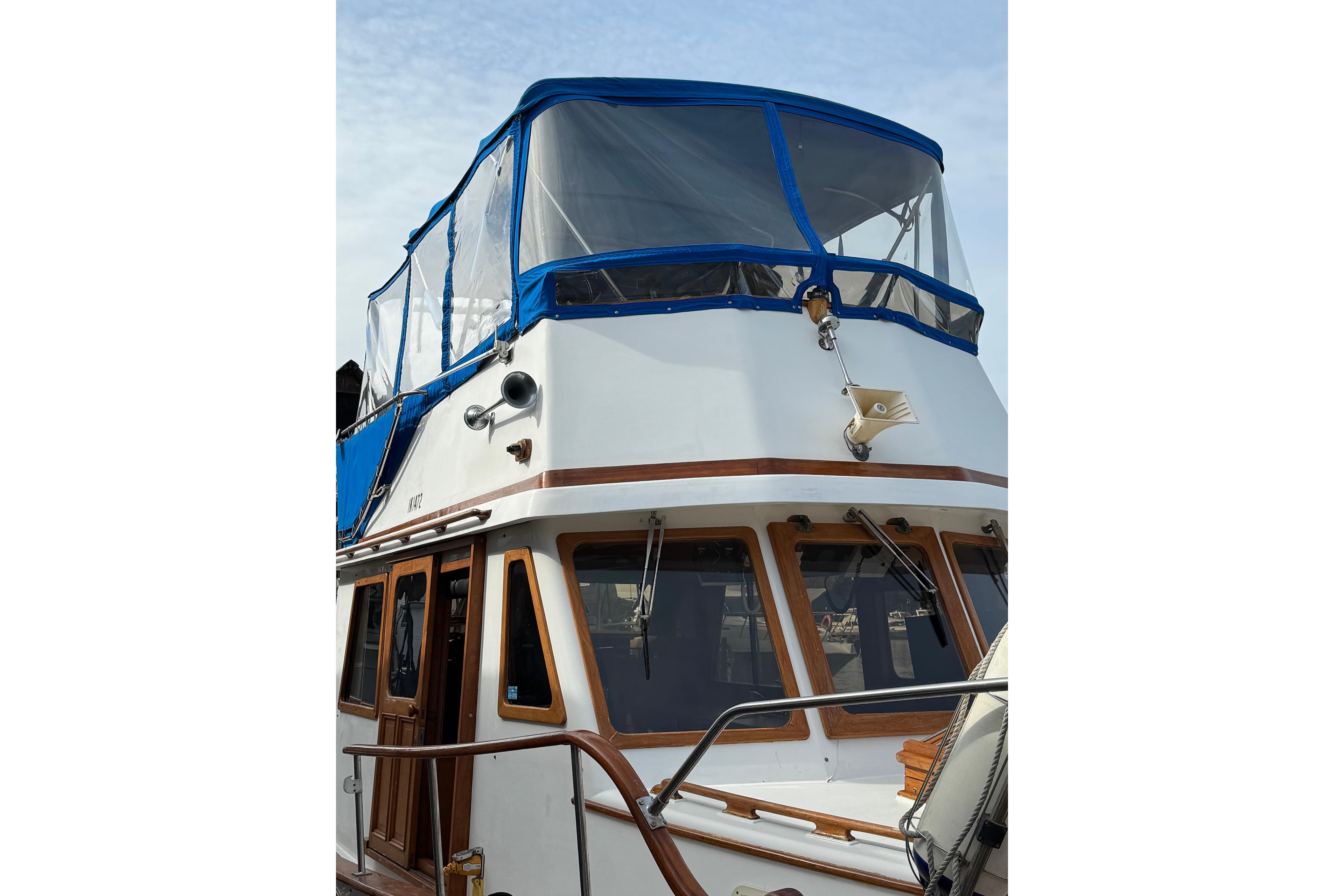 1980 CHB 35 boat with blue canopy, wooden accents, and white exterior.