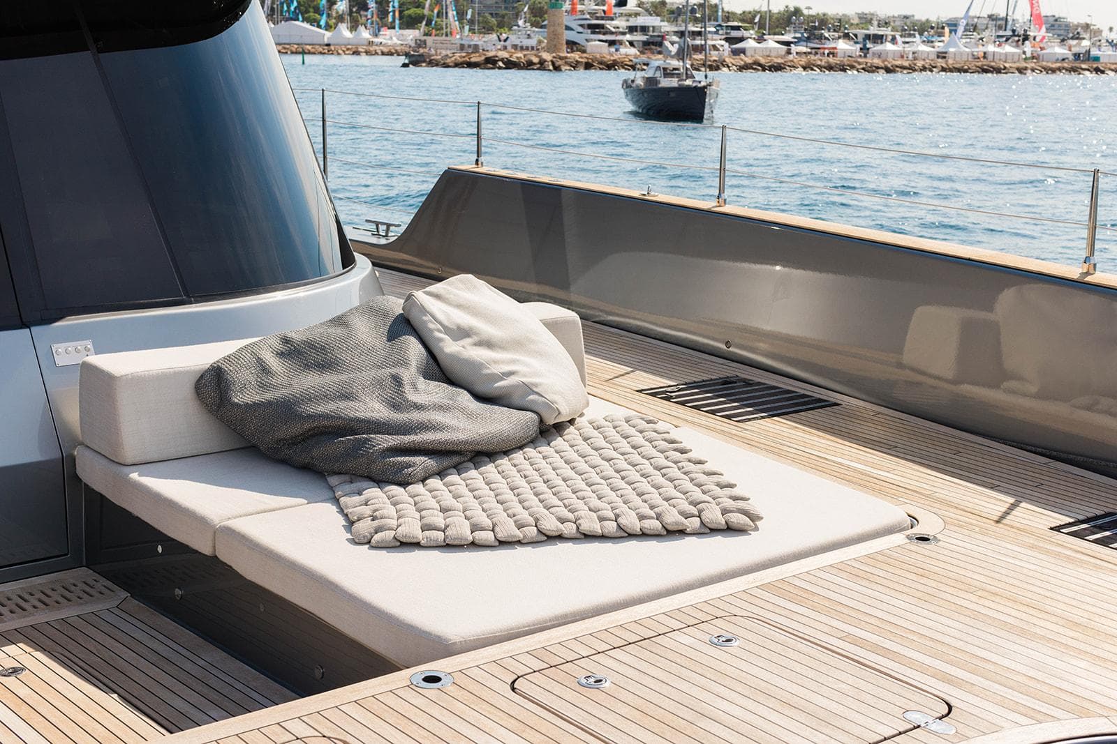 Luxurious Sunreef 80 Eco yacht deck with cozy seating, 2023 model, docked by the sea.