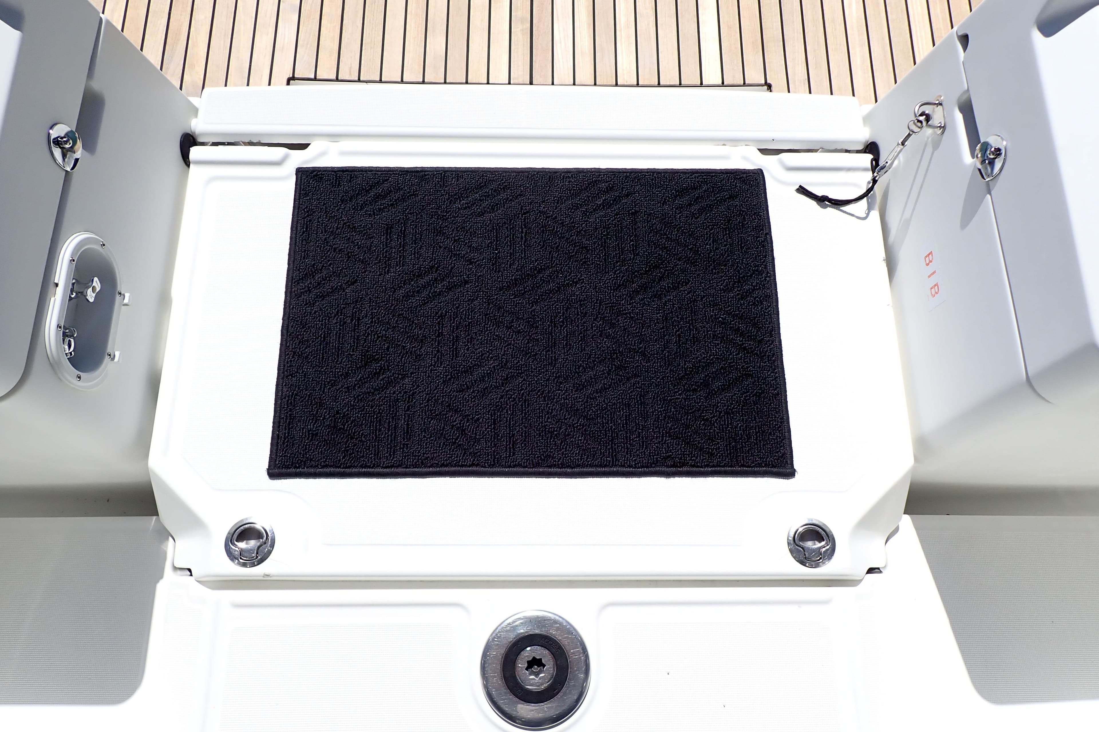 2018 Jeanneau Sun Odyssey 389 yacht deck with black mat and wooden flooring.