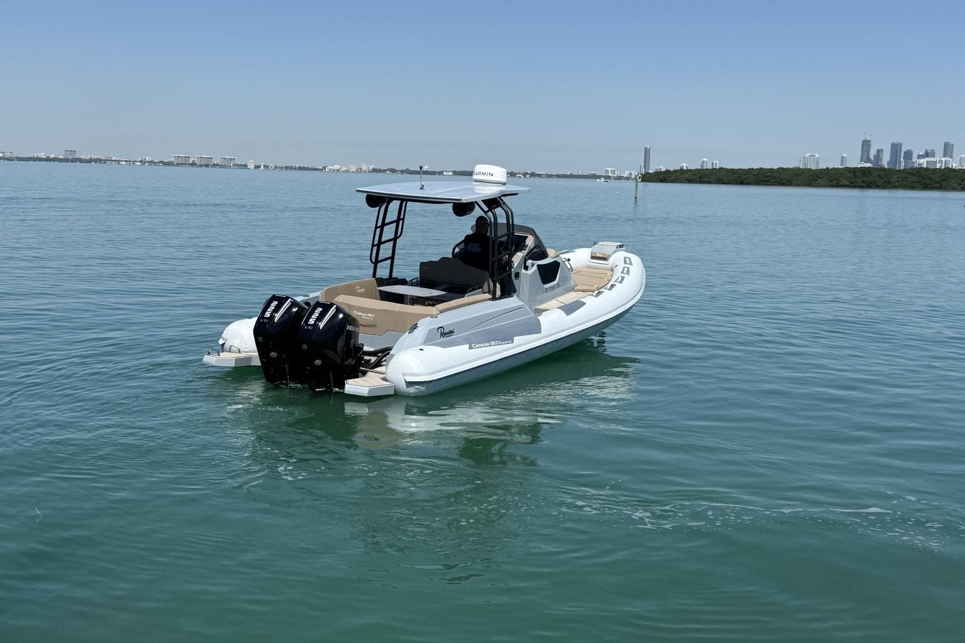 2026 Ranieri Cayman Executive boat on calm water with city skyline in background.