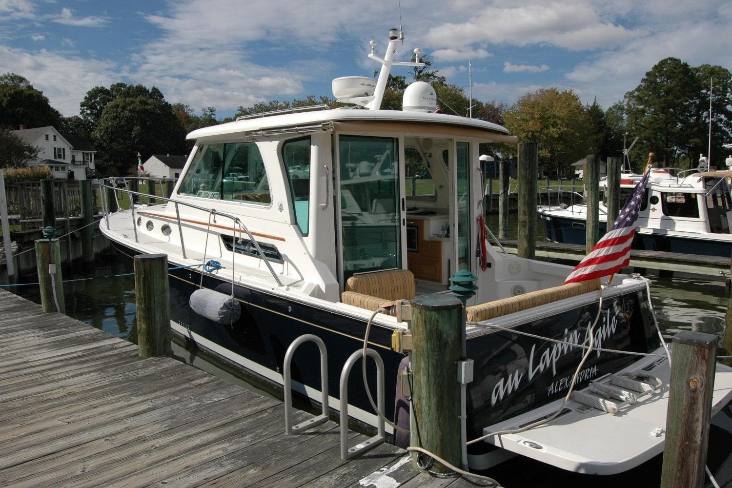 2014 Back Cove 34 boat docked, featuring American flag and scenic marina backdrop.