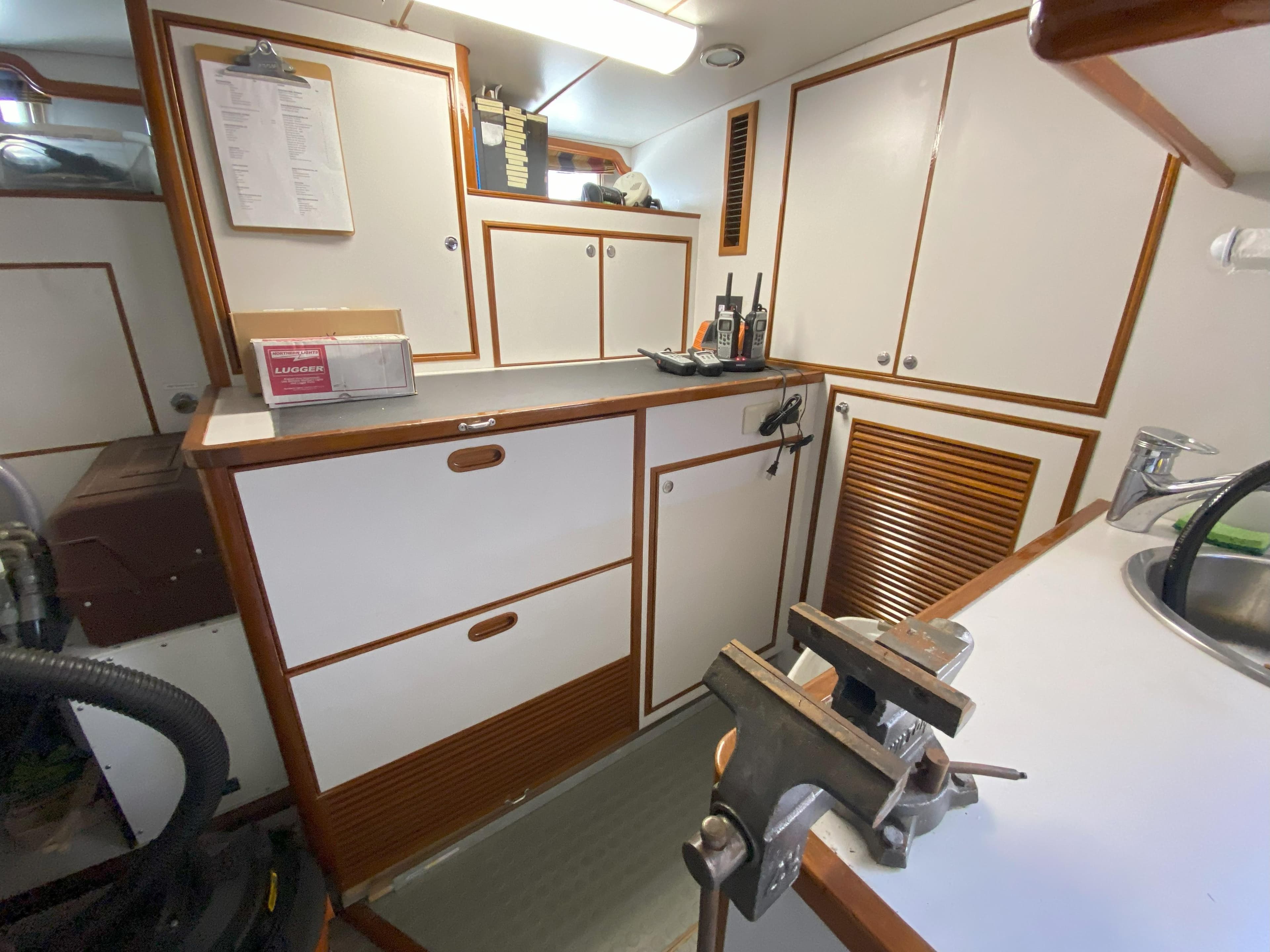 2005 Offshore Yachts 72' interior workspace with cabinets and tools.