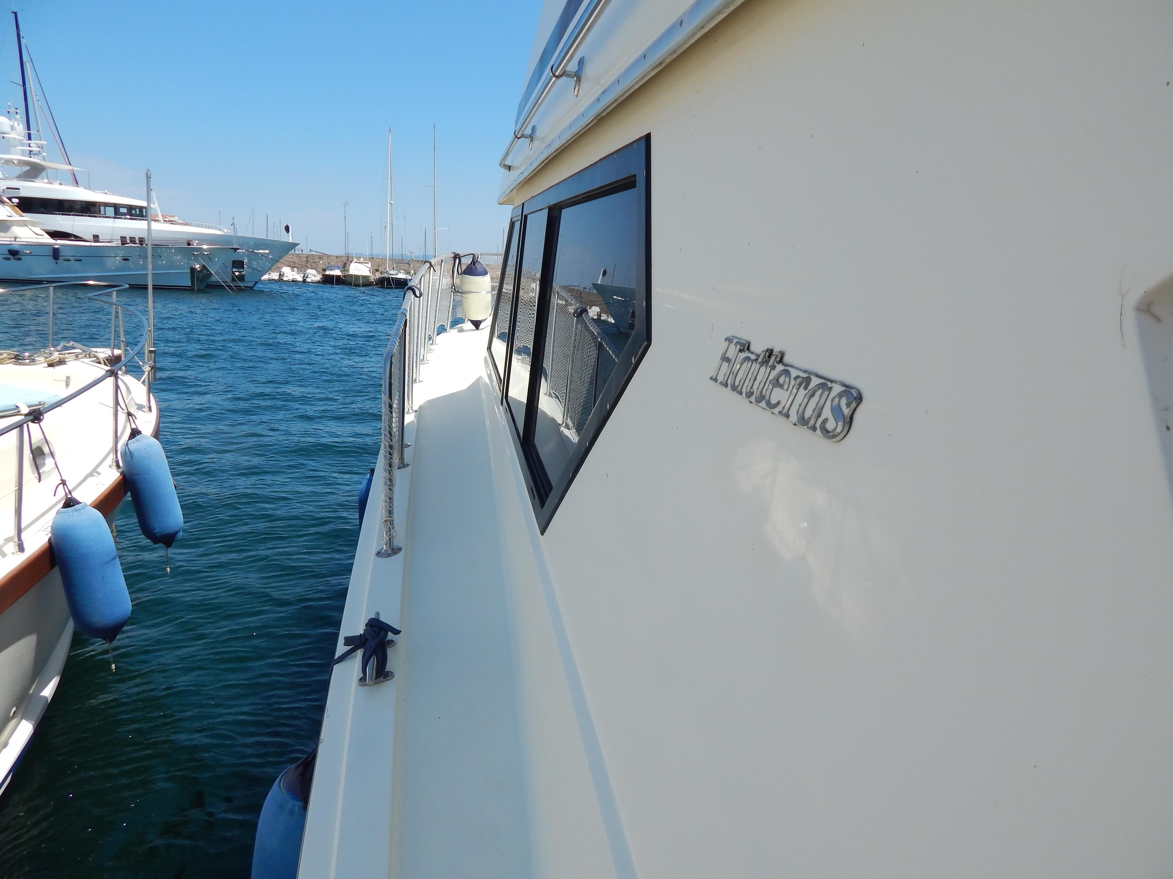 1989 Hatteras 45 Convertible yacht docked in a marina, side view.