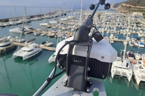 Rooftop view of a 2023 Lagoon 46 yacht in a marina, surrounded by boats.
