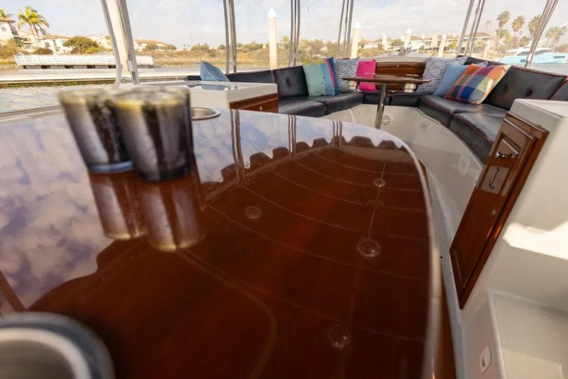 Luxurious interior of a 2014 Duffy 22 Bay Island boat with polished wood and colorful cushions.