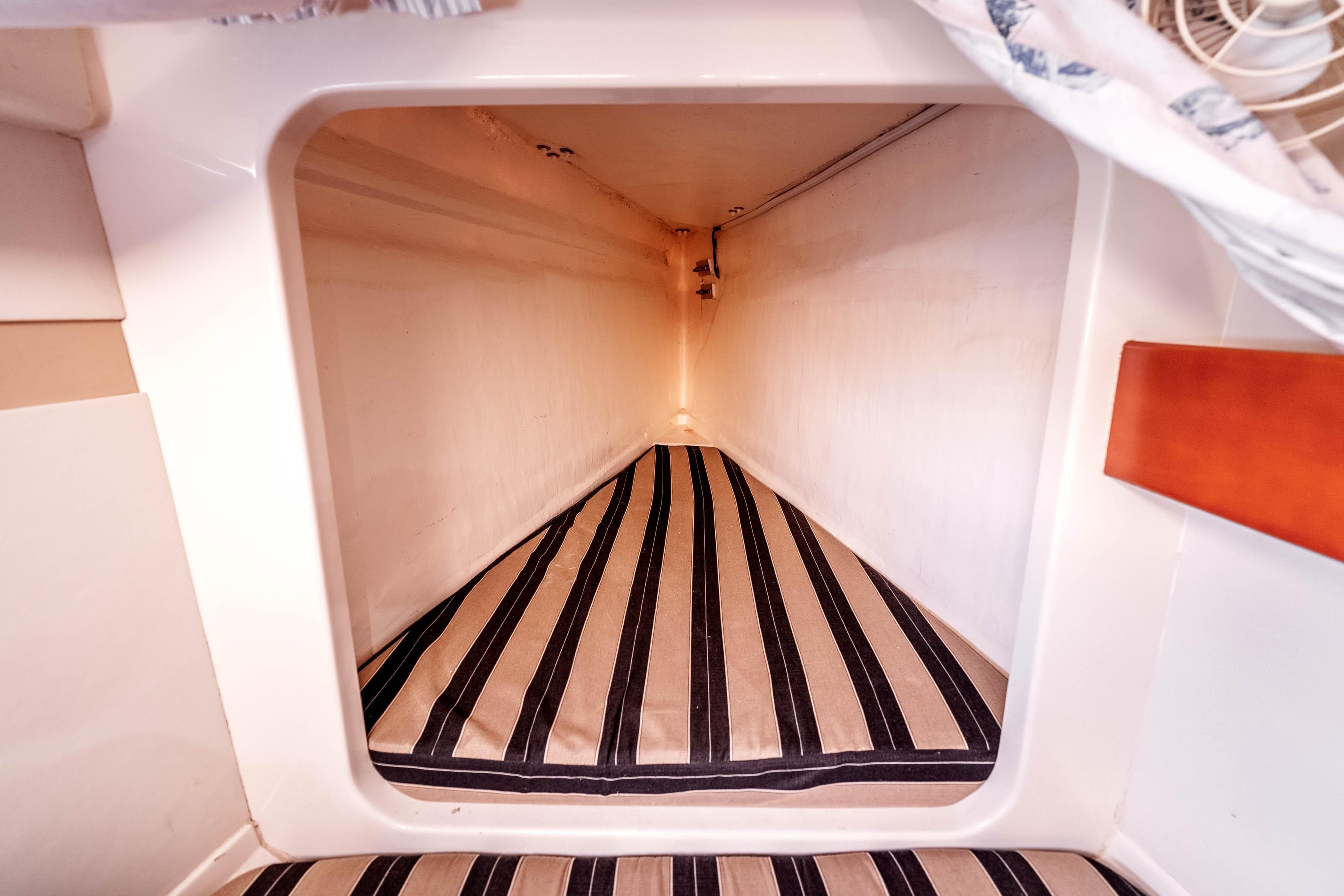 Interior view of a 2011 Leopard 39 yacht cabin with striped bedding.