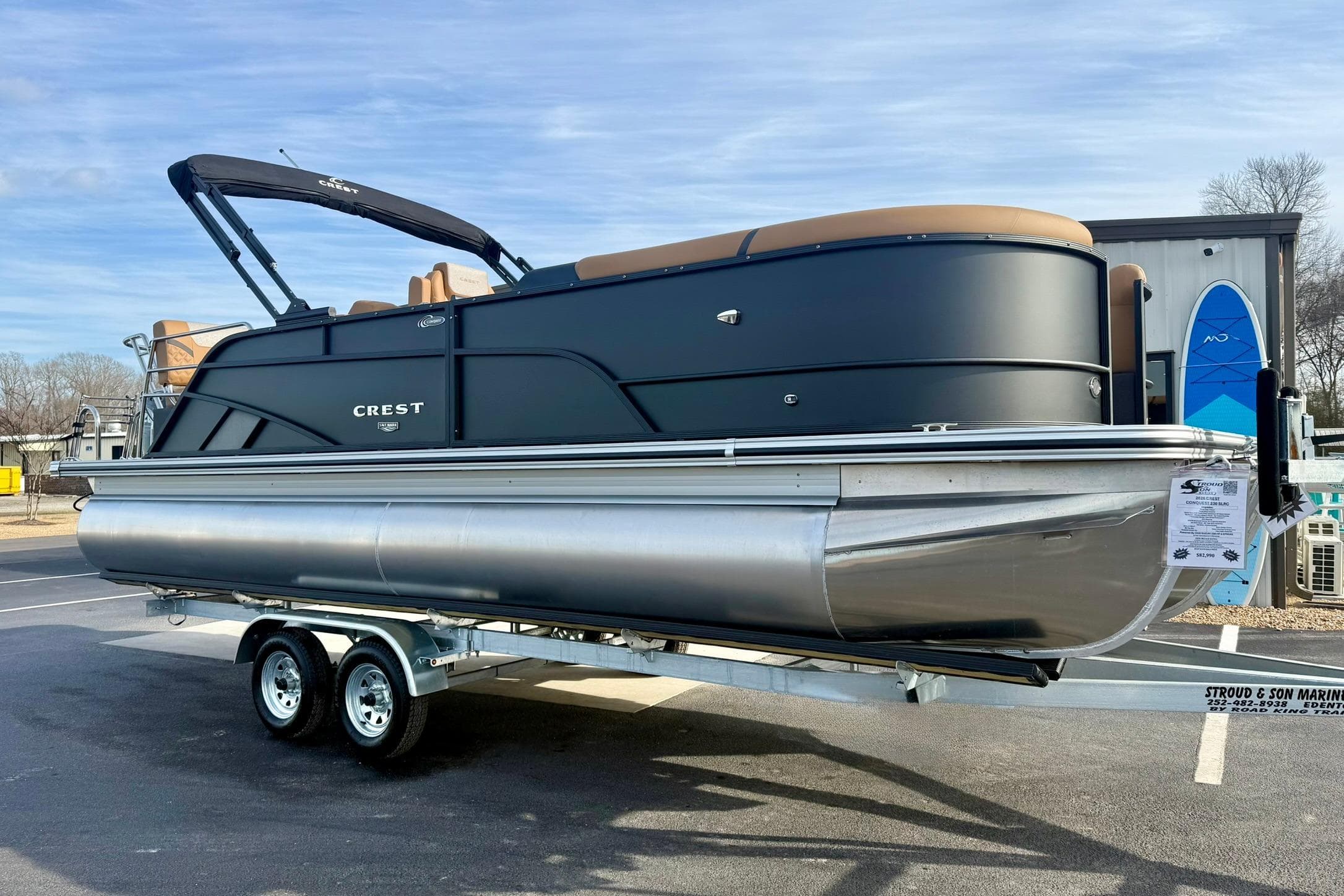 2026 Crest Conquest 230 SLRC pontoon boat on trailer, sleek black design.