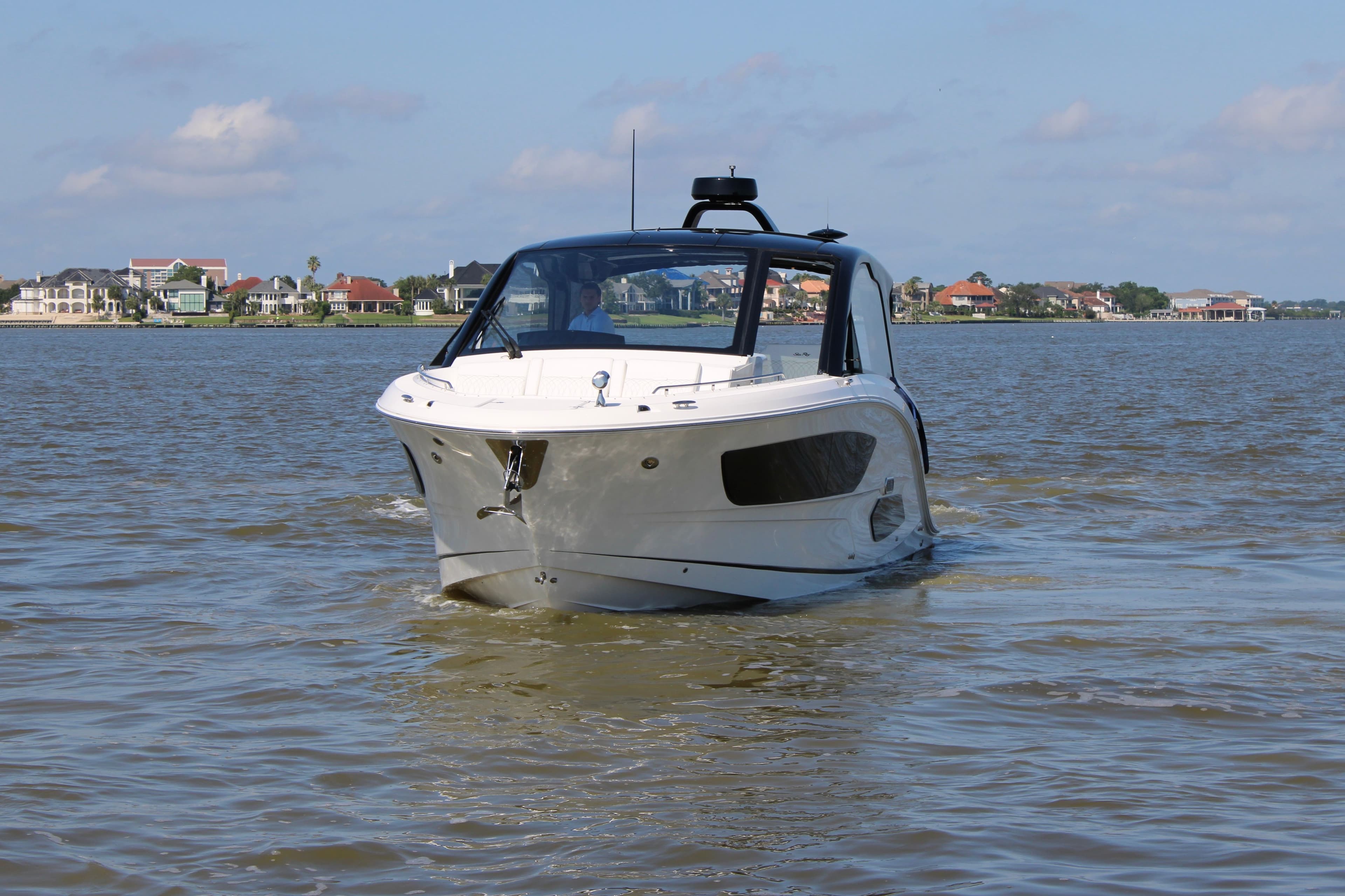 2026 Sea Ray Sundancer 370 Outboard on calm water near coastal homes.