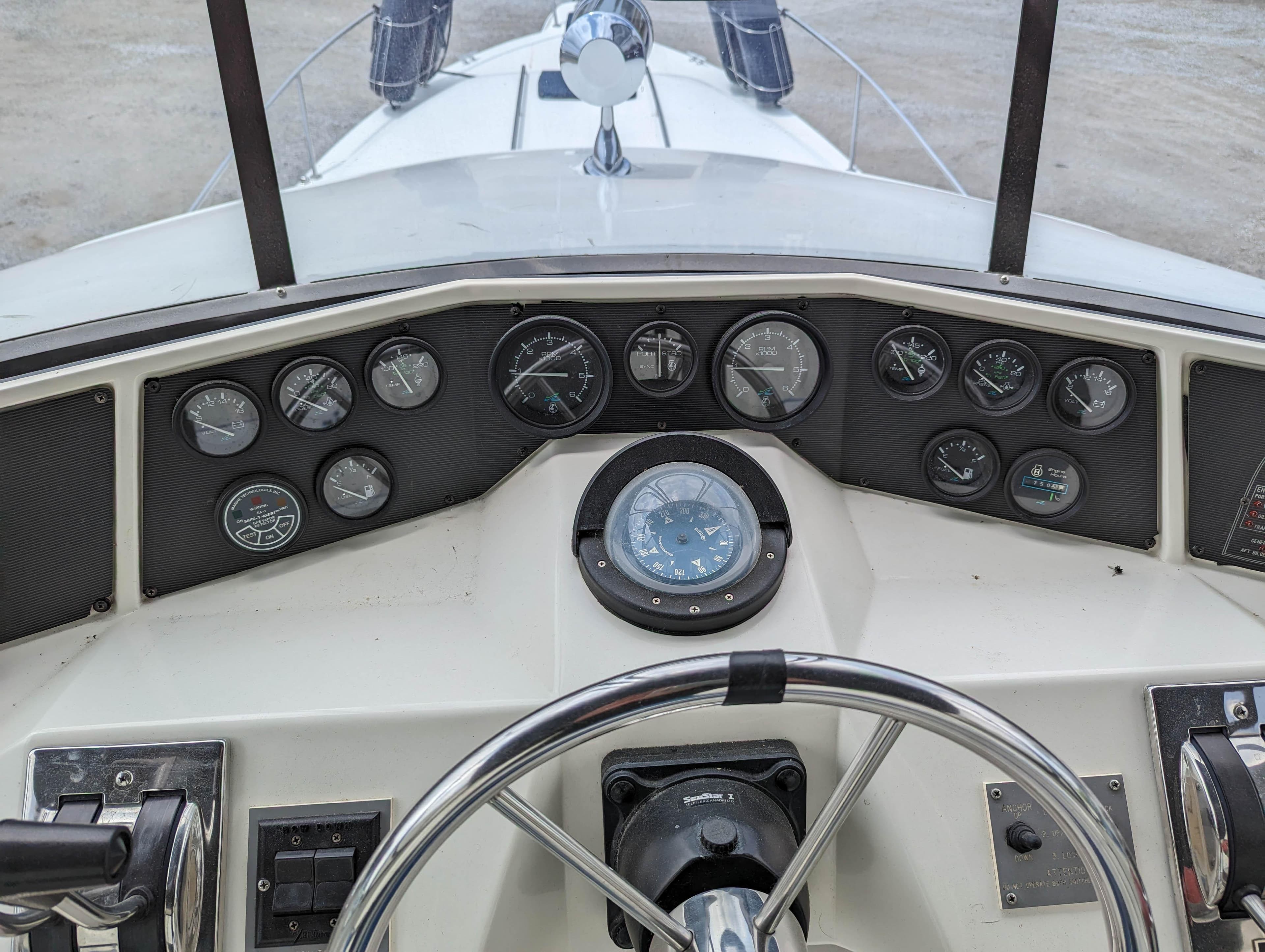 1989 Sea Ray 340 Sedan Bridge dashboard with steering wheel and instrument gauges.
