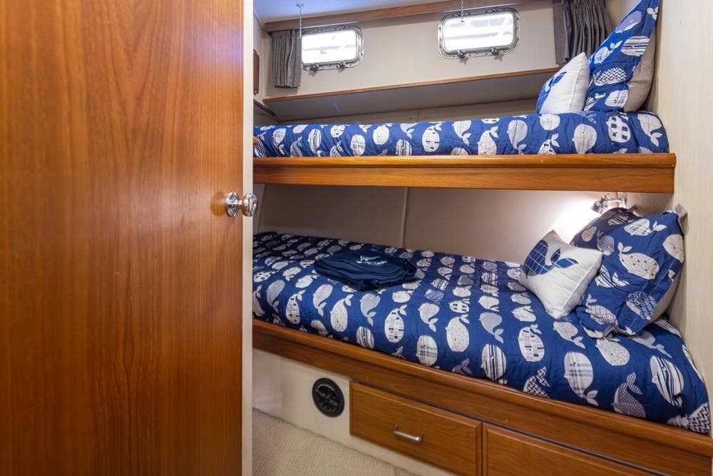Bunk beds in 1991 Tollycraft 57 Pilothouse Motor Yacht cabin with nautical-themed bedding.