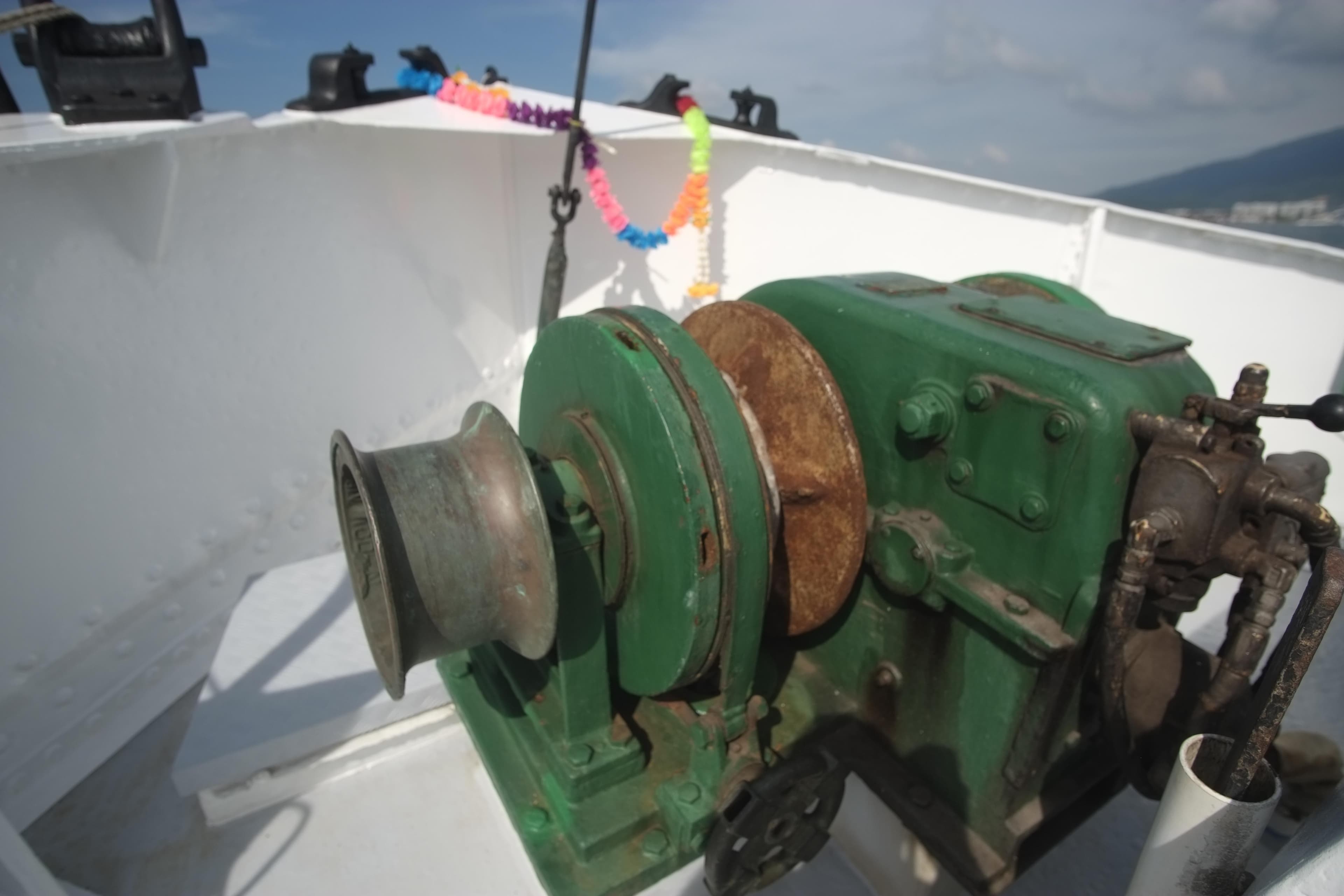 Vintage 1930 Custom Gronigen ship winch with green metal casing on deck.