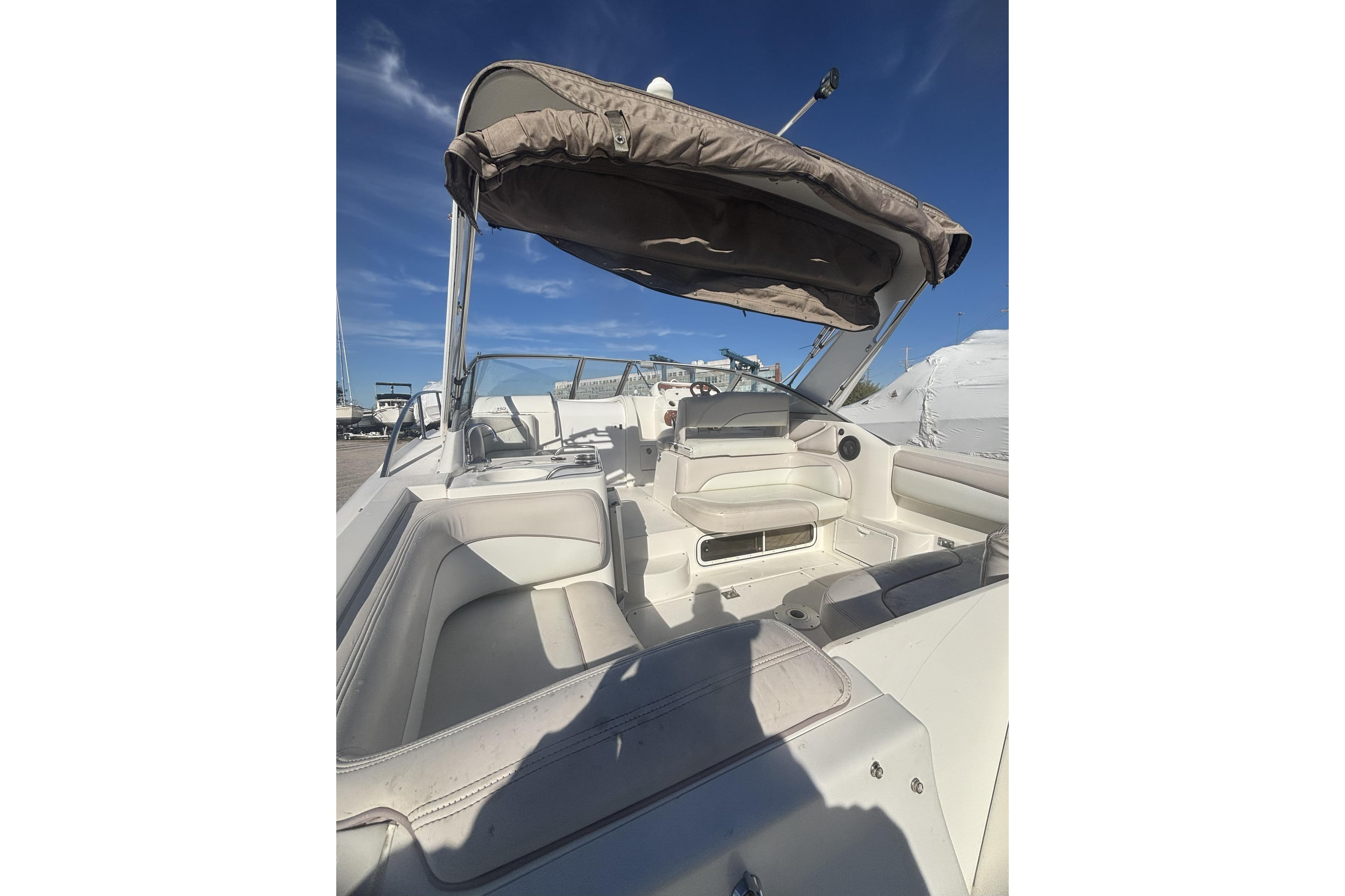 2000 Larson Cabrio 330 Mid Cabin boat interior with seating and canopy under clear sky.