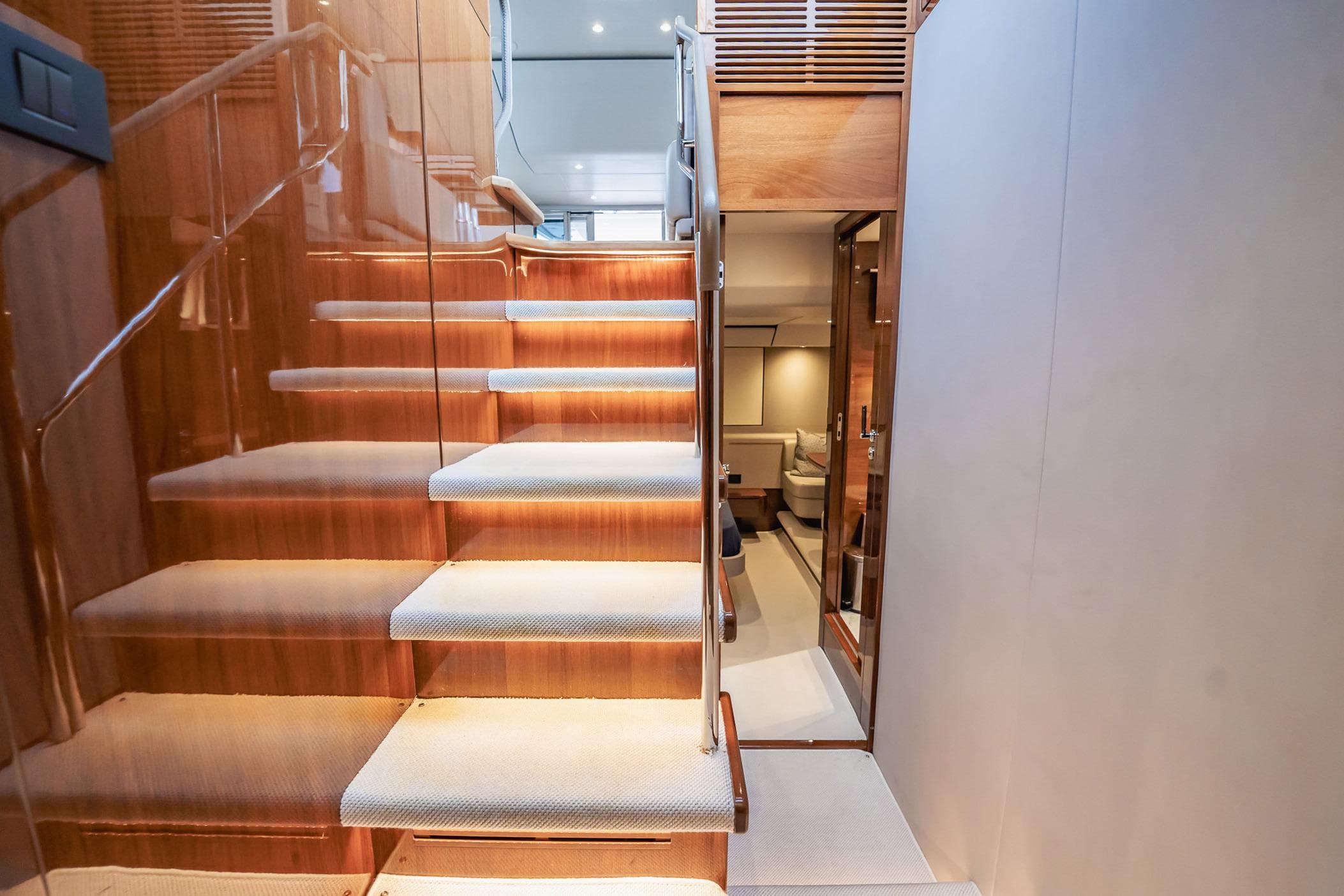 Luxurious interior staircase of 2019 Princess F55 yacht with elegant wood finish.