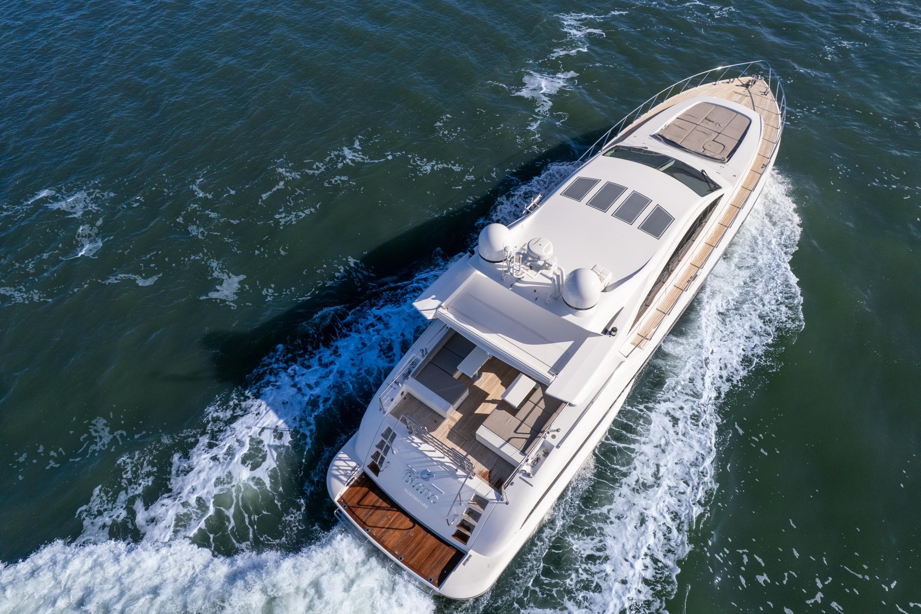 Luxury 2007 Mangusta 80 yacht cruising on open water, aerial view.