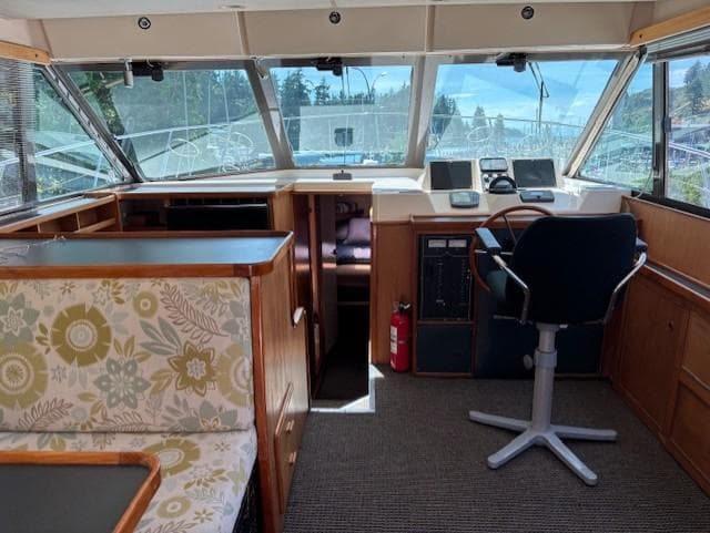 Interior of a 1988 Riviera Convertible boat with helm, seating, and floral upholstery.