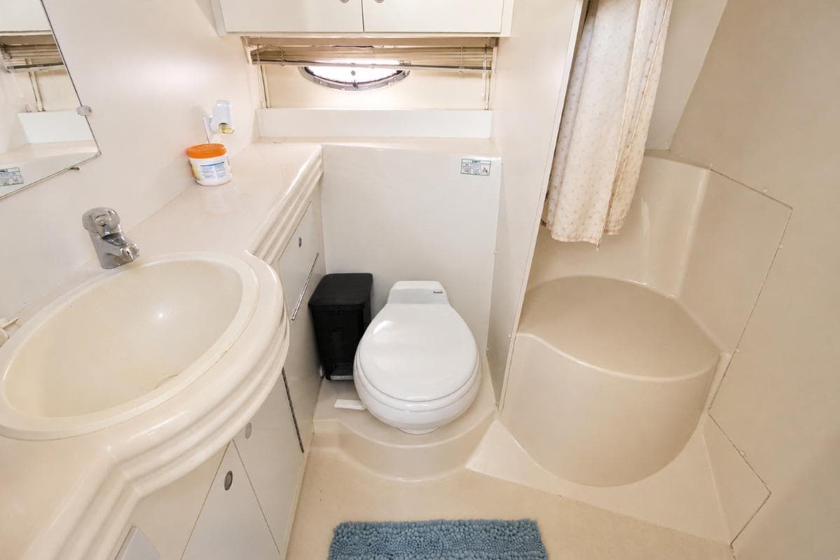 Bathroom interior of 1996 Cruisers Yachts 3580 Flybridge with sink, toilet, and shower.