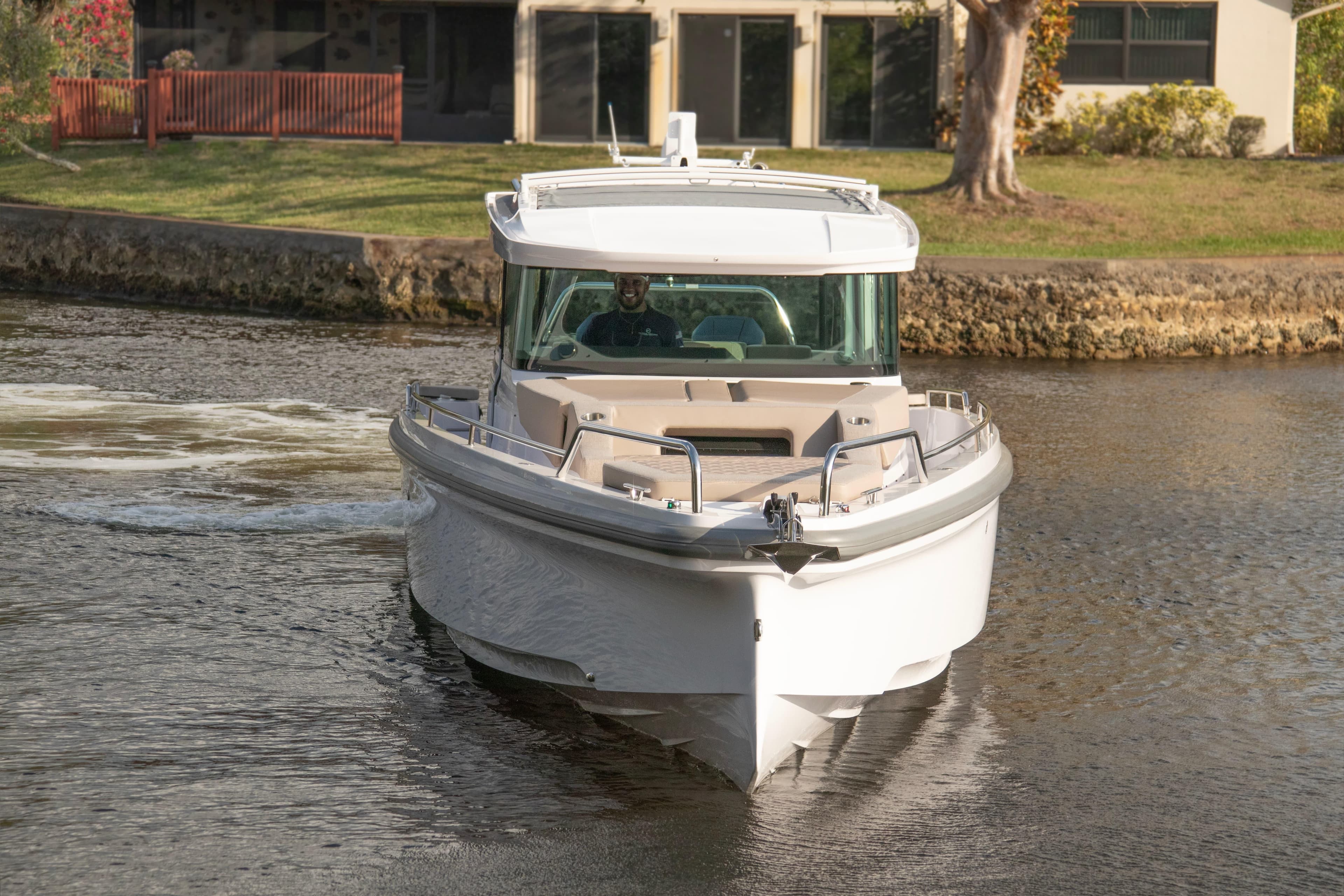 2024 Axopar 37XC CROSS CABIN boat cruising on a calm waterway.