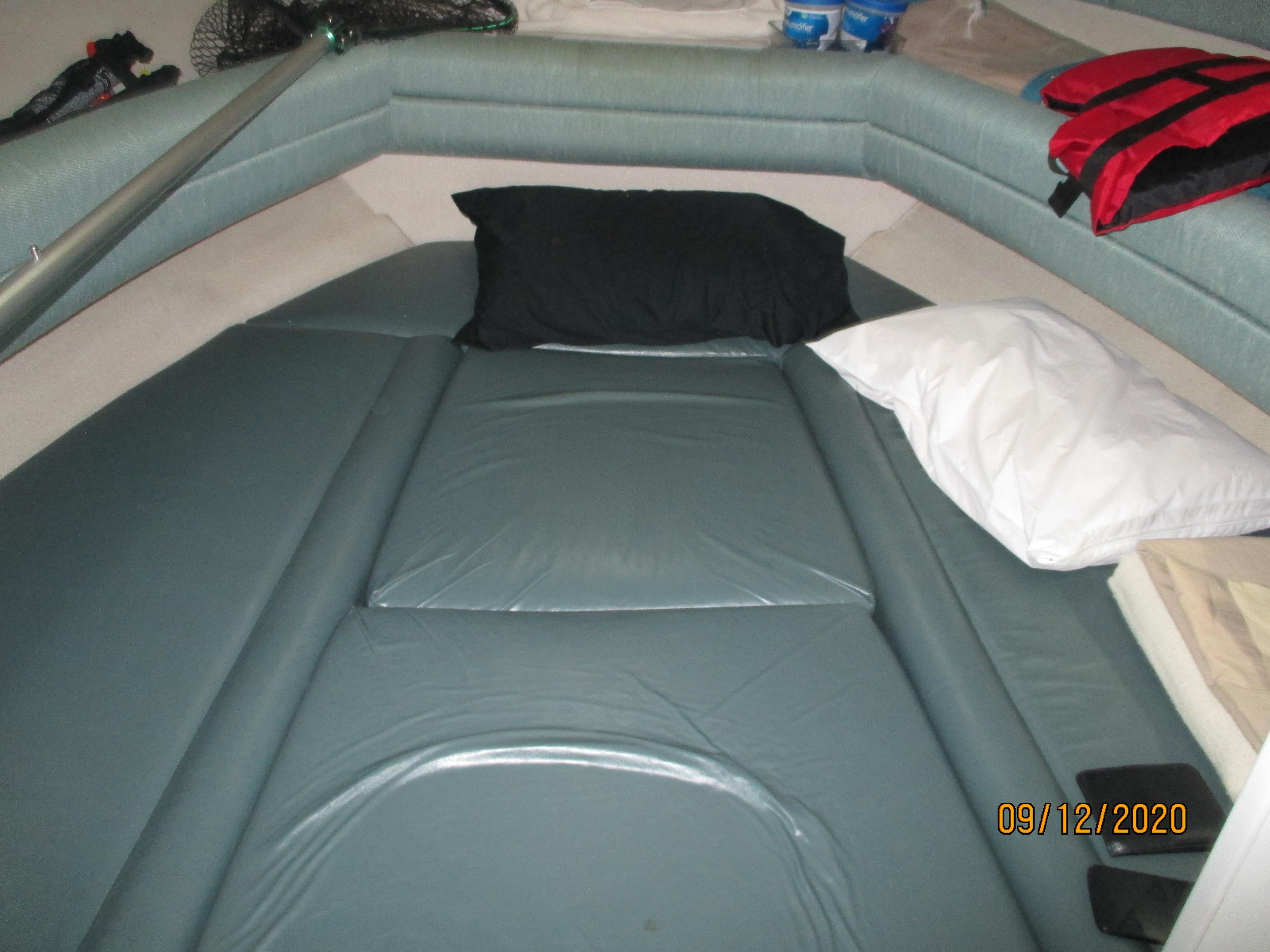 Interior cabin of 1994 Rinker Fiesta Vee 265 with cushions and pillows.