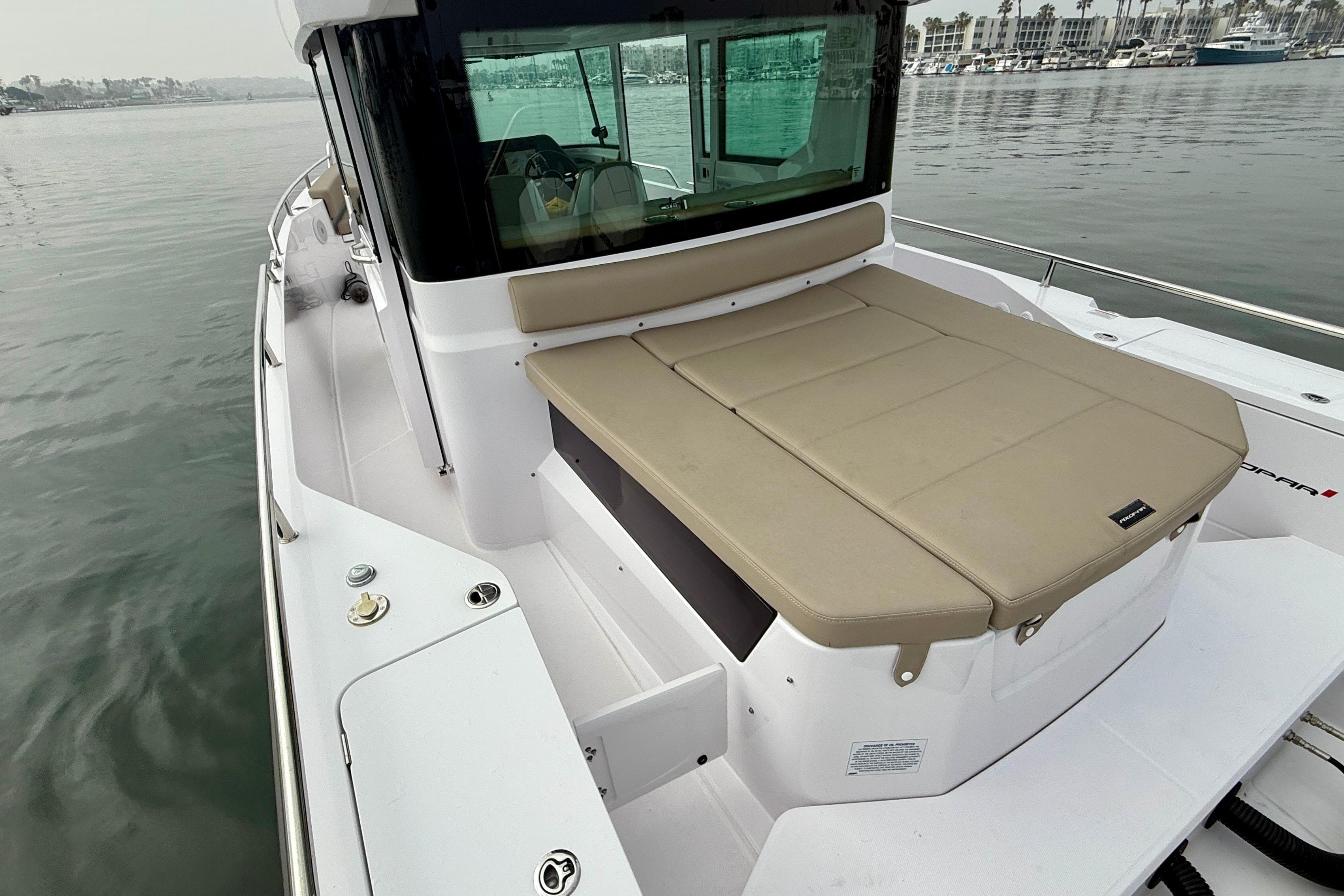 2023 Axopar 28 Cabin boat with beige seating, docked in a marina.