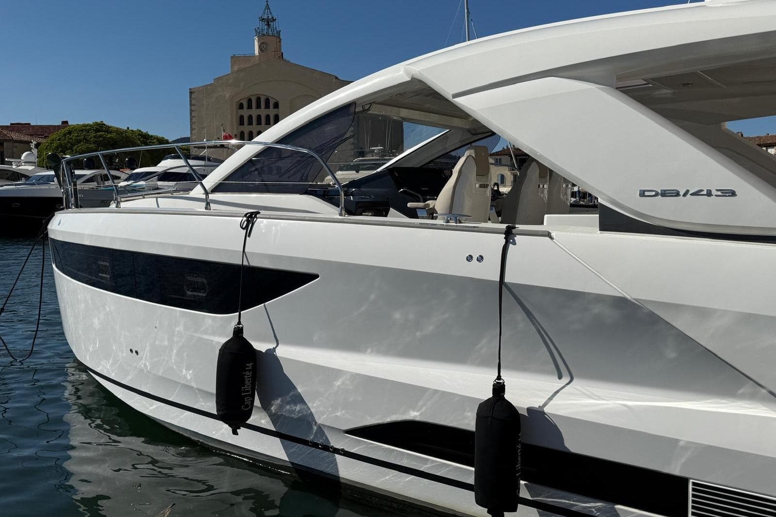 2023 Jeanneau DB/43 IB yacht docked in a marina, showcasing sleek design and modern features.