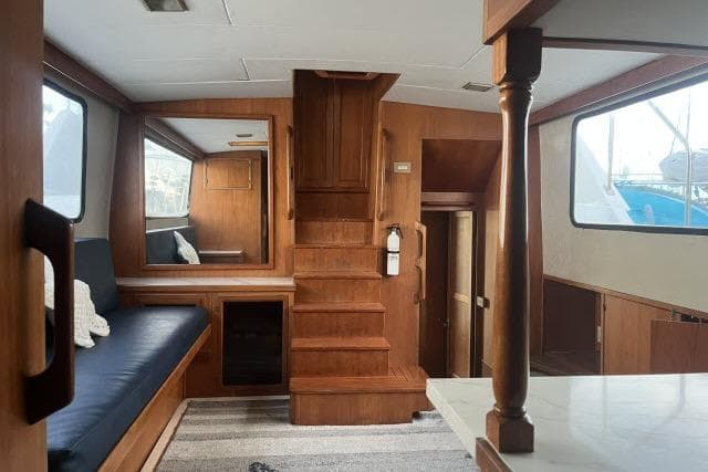 1988 Kadey Krogen 42 interior with wooden finish, staircase, and seating area.