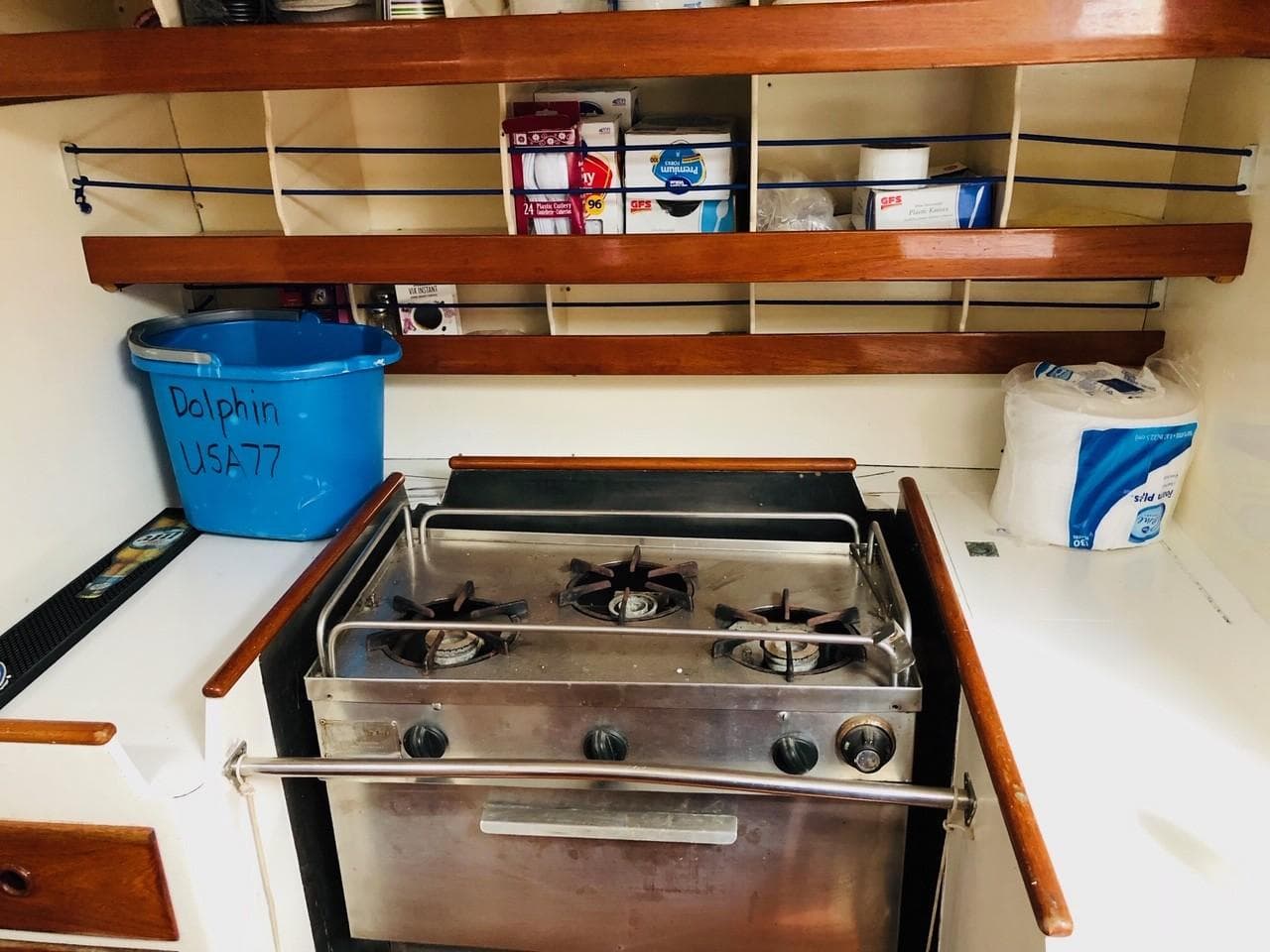 1973 Mull 54 boat kitchen with stove, shelves, and storage.