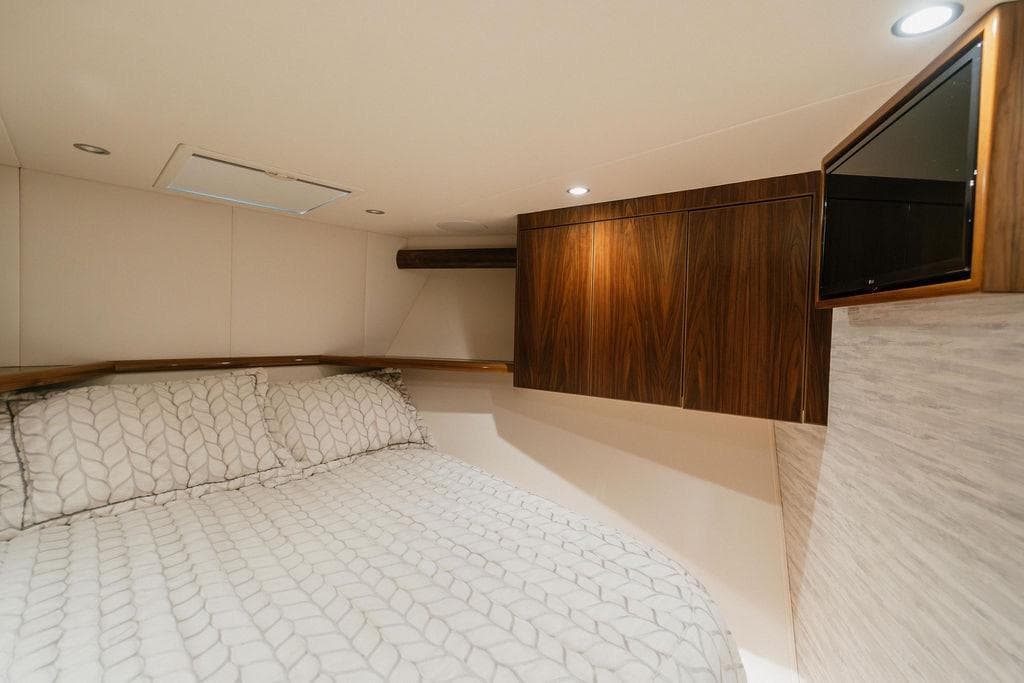 Luxurious bedroom interior of 2021 Viking 58 Convertible yacht with elegant wood cabinetry.